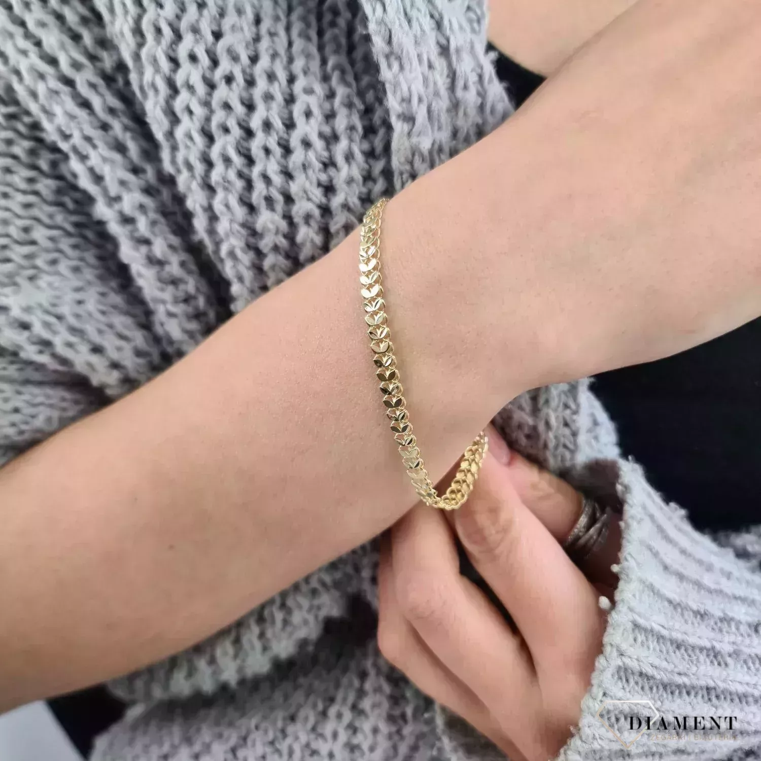 Złota bransoletka damska 375 Płaska złota taśma, wzór kłosa DIA-BRA-11183-375  Bransoletka damska wykonana z żółtego złota próby 375. Damska bransoletka o płaskiej formie. Złota biżuteria idealna na prezent. (2).webp