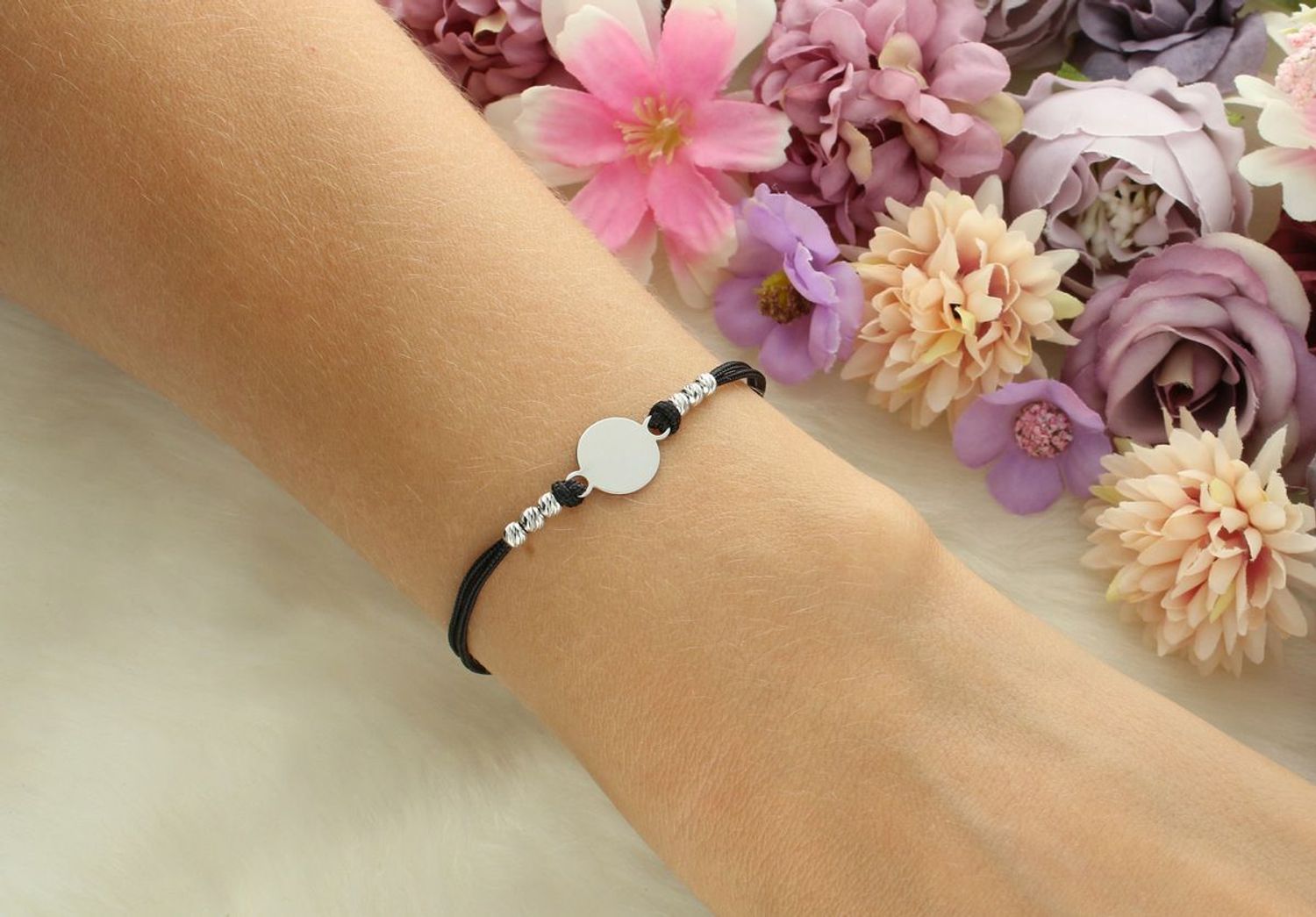 Delikatna bransoletka damska ze srebra 925 z czarnym sznureczkiem i okrągłą blaszką 9 mm. Długość 16 cm + 3 cm, zapięcie na karabińczyk. Model DIA-BRA-12672-925 – lekka i elegancka biżuteria.1.jpg