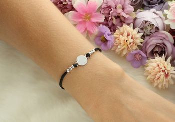 Delikatna bransoletka damska ze srebra 925 z czarnym sznureczkiem i okrągłą blaszką 9 mm. Długość 16 cm + 3 cm, zapięcie na karabińczyk. Model DIA-BRA-12672-925 – lekka i elegancka biżuteria.3.jpg