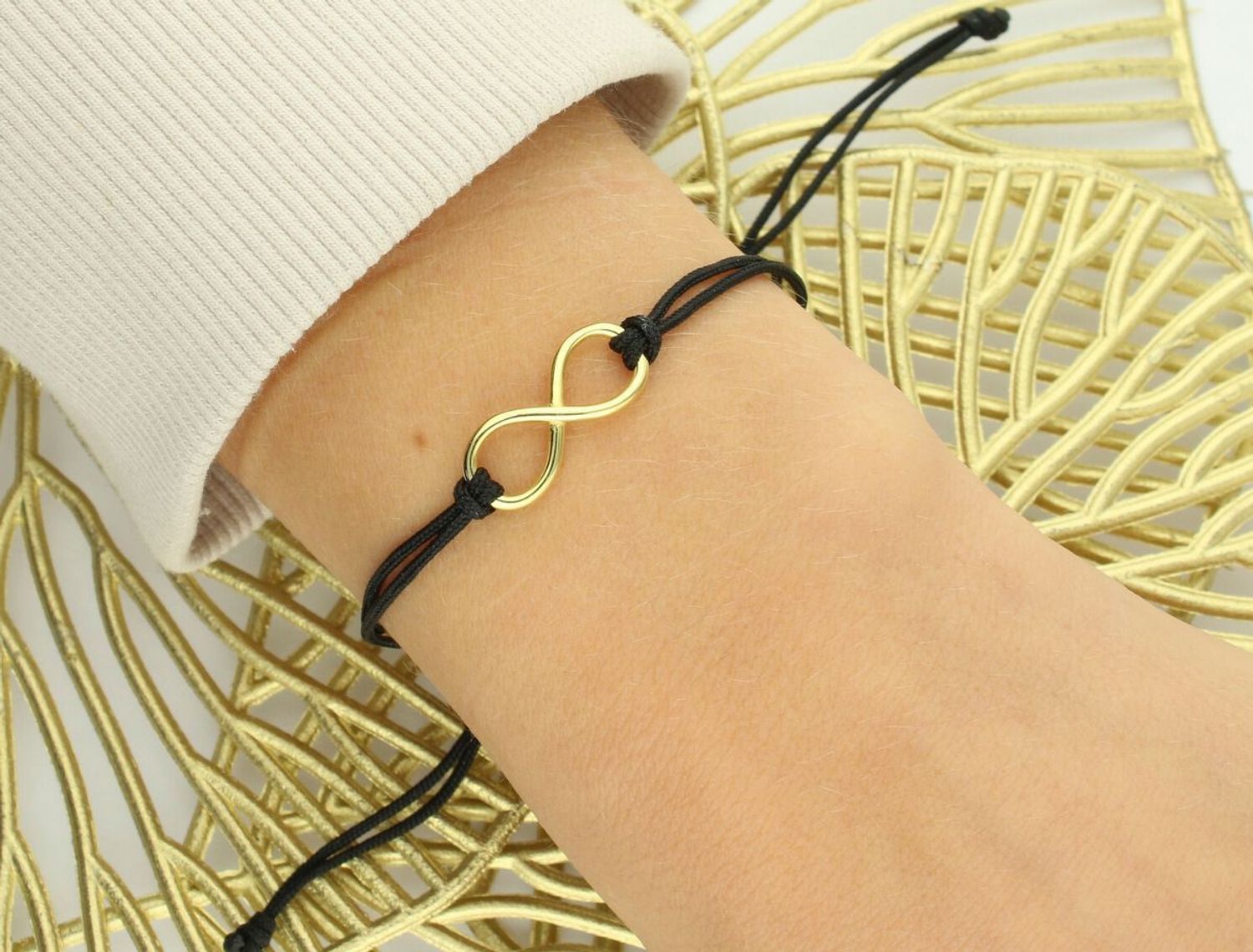 Elegancka bransoletka damska ze srebra próby 925 pozłacana, z zawieszką znak nieskończoności. Czarny sznurek, ściągane zapięcie, regulowana długość, idealna na prezent.1.jpg