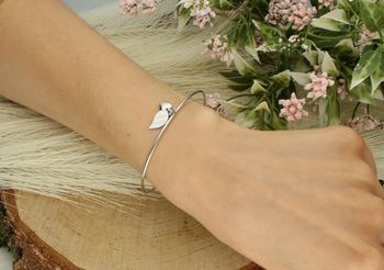 Bransoletka srebrna 925 DIA-BRA-5332-925 – sztywna z zawieszkami serduszkiem (6 mm) i piórkiem (1 cm). Zapięcie na karabińczyk, waga 4,79 g. Subtelna, kobieca biżuteria.2.jpg