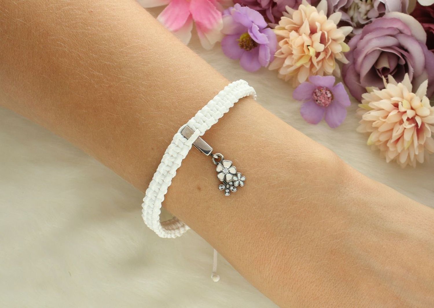 Delikatna srebrna bransoletka 925 z wiszącą zawieszką w kształcie kwiatków na białym sznurku. Regulowane zapięcie, subtelny design – idealna na prezent lub na co dzień.1.jpg