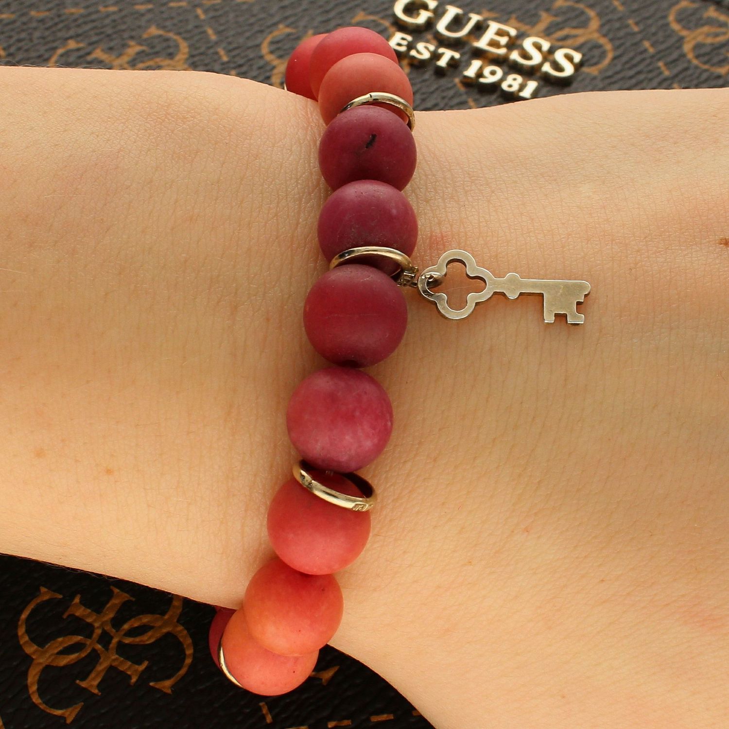 Bransoletka damska Czerwone Koraliki z zawieszką kluczem DIA-BRA-5638-INNE. Bransoletka damska z zawieszką. Bransoletka koraliki z kluczem. Bransoletka damska w czerwonym odcieniu. Bransoletka na każdą okazję (1).jpg
