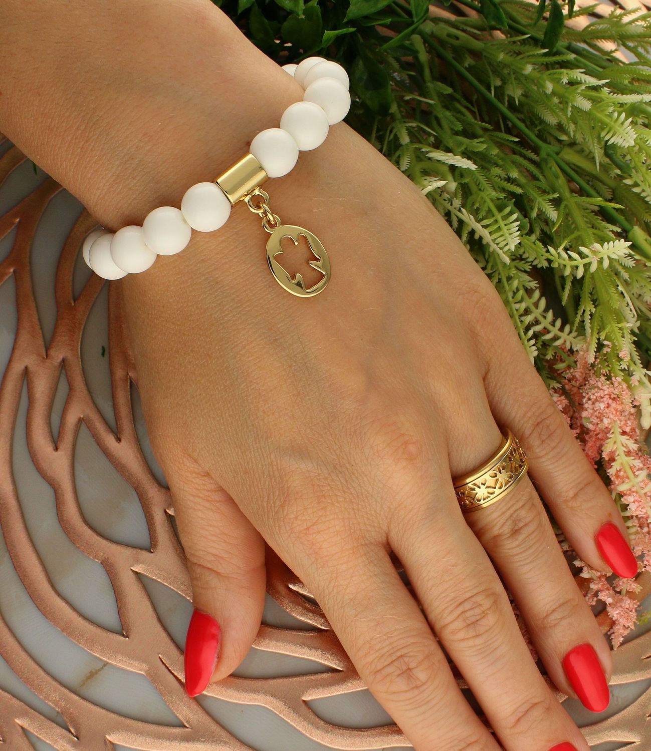 Bransoletka damska na gumce białe koraliki z aniołkiem  DIA-BRA-5674-INNE. Bransoletka damska z koralików. Bransoletka damska biała. Bransoletka damska z pozłacanymi elementami. Bransoletka damska z zawieszką aniołek (1).jpg