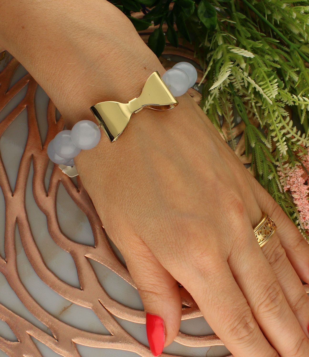 Bransoletka damska na gumce błękitne koraliki z pozłacaną kokardką DIA-BRA-5681-INNE. Bransoletka damska koraliki. Bransoletka damska niebieska. Bransoletka damska ze złotymi zawieszkami. Bransoletka damska na gumce. Bransolet (1).jpg