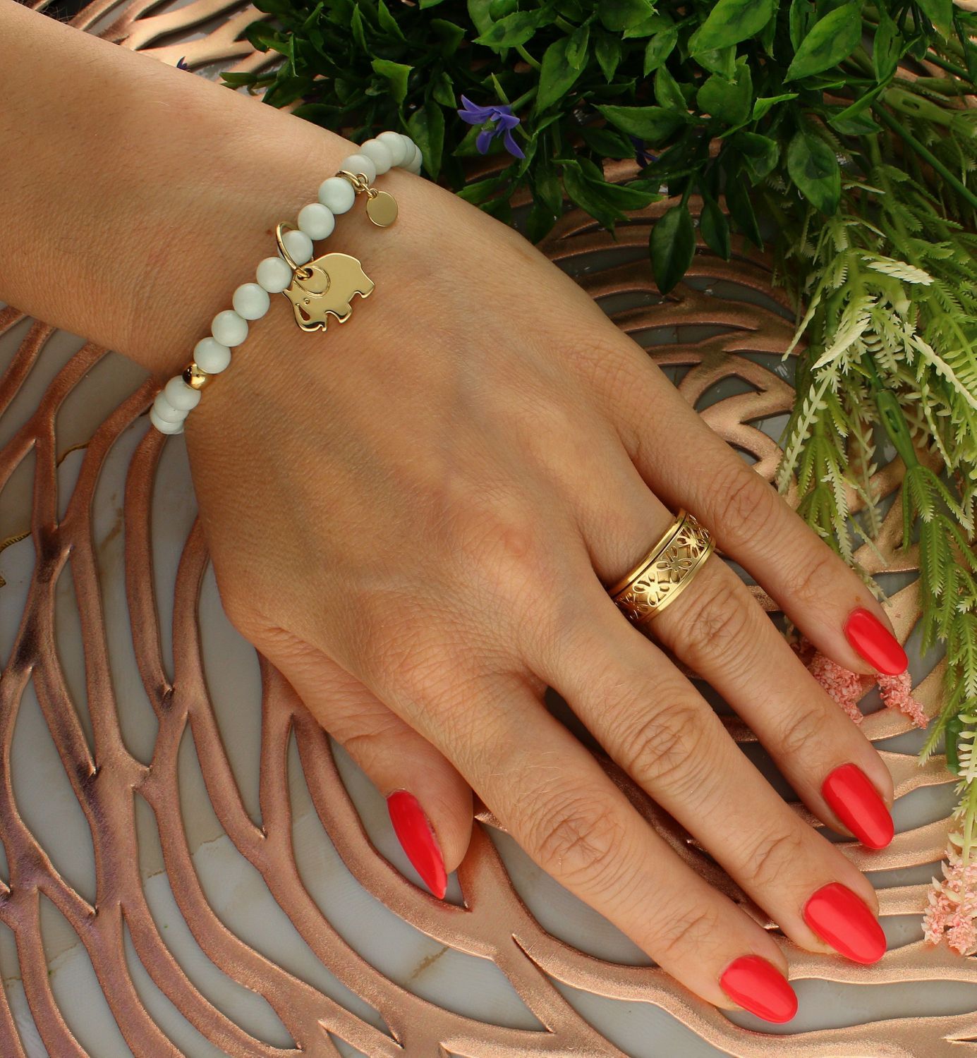 Bransoletka damska na gumce mleczne koraliki z pozłacanym słonikiem DIA-BRA-5684-INNE. Bransoletka damska z koralików. Bransoletka damska mleczna. Bransoletka damska z pozłacanymi elementami. Bransoletka damska z zawieszką s.jpg