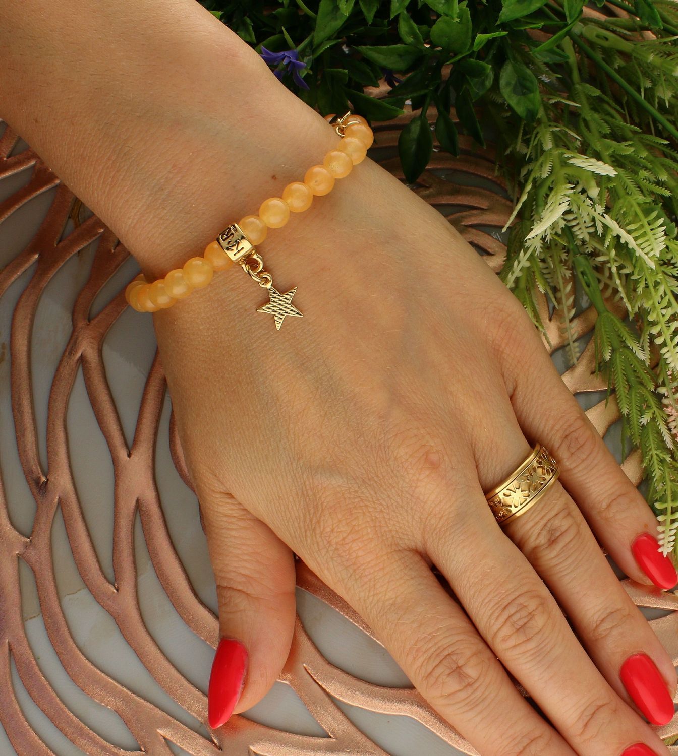 Bransoletka damska na gumce pomarańczowe koraliki z pozłoconą gwiazdką DIA-BRA-5700-INNE. Bransoletka damska na gumce. Bransoletka damska z koralików. Bransoletka damska pomarańczowy kolor. Bransoletka damska z zawieszką gwi.jpg