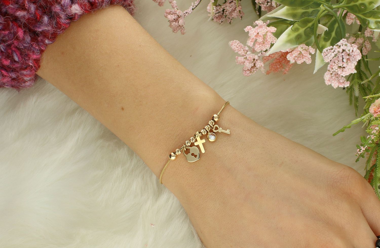 Złota bransoletka 585 z wiszącymi elementami . Złota bransoletka o niezwykle kobiecym wzorze, w którym bardzo delikatny splot łańcuszka ozdobiono elementami w kształcie kluczyka, krzyżyka, cyrkonii i serduszka.1.jpg