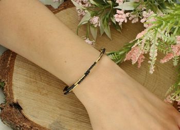 Delikatna srebrna bransoletka DIA-BRA-8860-925 sztywna z czarnymi grawerowanymi kuleczkami, pozłacanymi akcentami i zawieszką w kształcie serduszka. Elegancki dodatek z srebra próby 925 (2).jpg