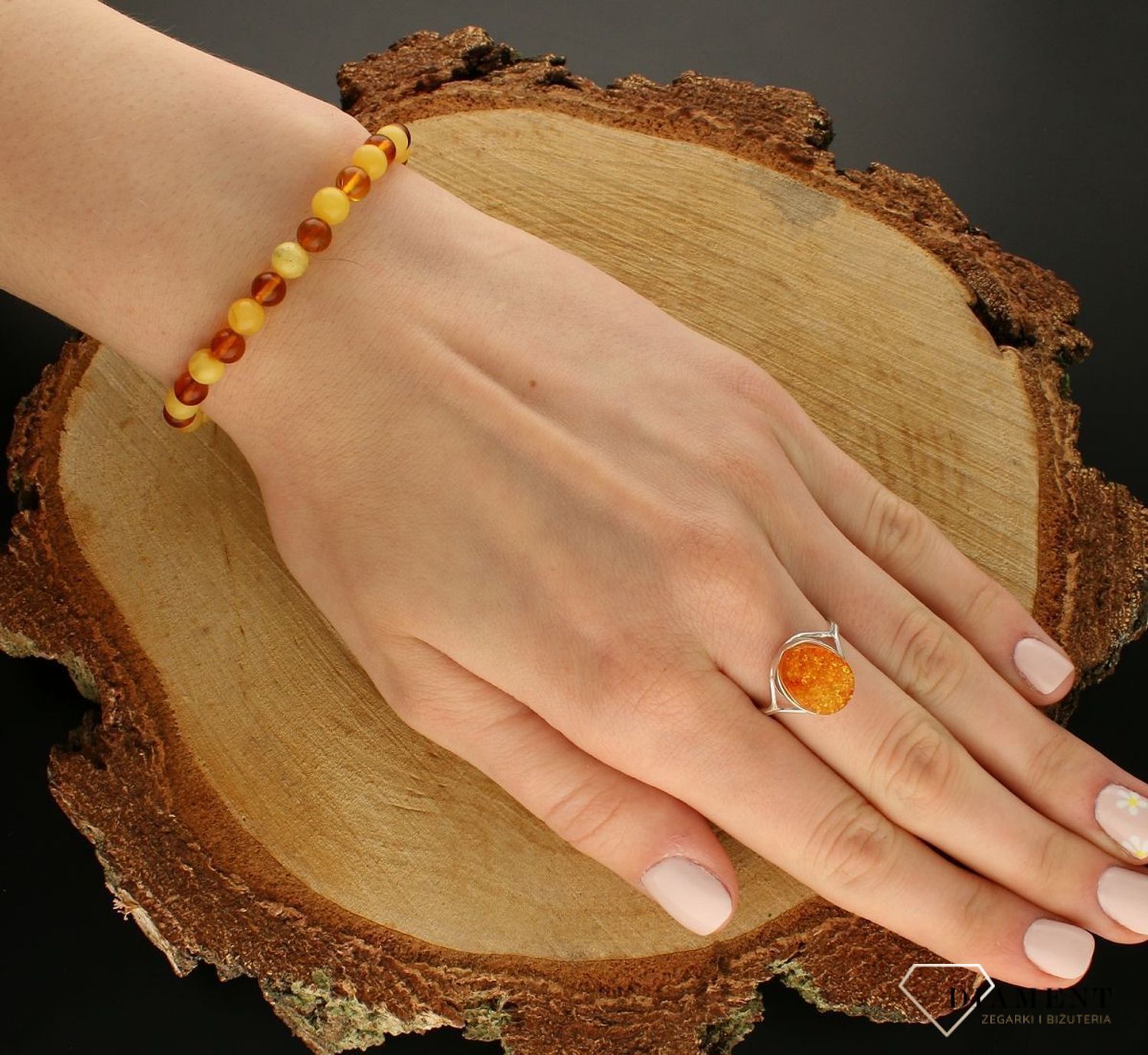 Bransoletka damska na gumce z brązowym i żółtym bursztynem DIA-BRA-9845-BURSZTYN.  Bursztyn to propozycja od sklepu jubilerskiego Diament.  Bransoletka z bursztynu będzie ciekawą ozdobą dla wielu kreacji jak również idealnym pomysł (3).jpg