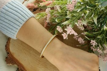 Sztywna bransoletka damska ze stali pozłacanej, zdobiona zakuwanymi cyrkoniami. Obwód 17 cm, szerokość 4 mm. Elegancka i trwała biżuteria na każdą okazję.2.jpg
