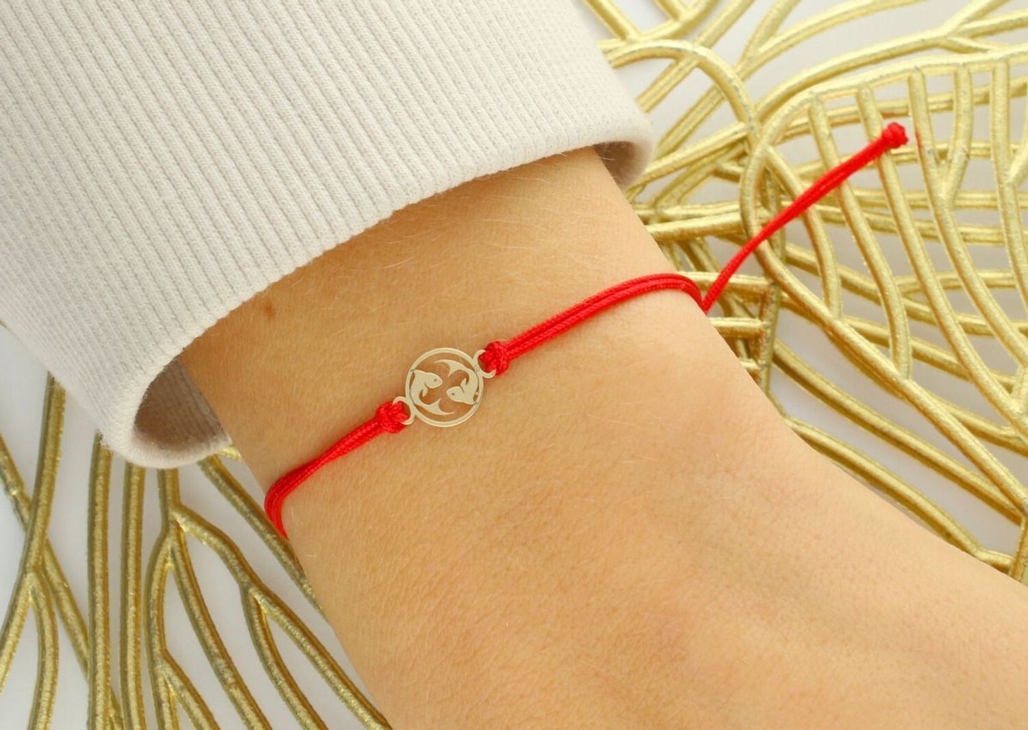 Subtelna bransoletka damska ze złota próby 585 na czerwonym sznurku z okrągłą zawieszką symbolem zodiaku Ryby. Ściągane zapięcie, regulowana długość, idealna na prezent lub osobisty talizman.1.jpg