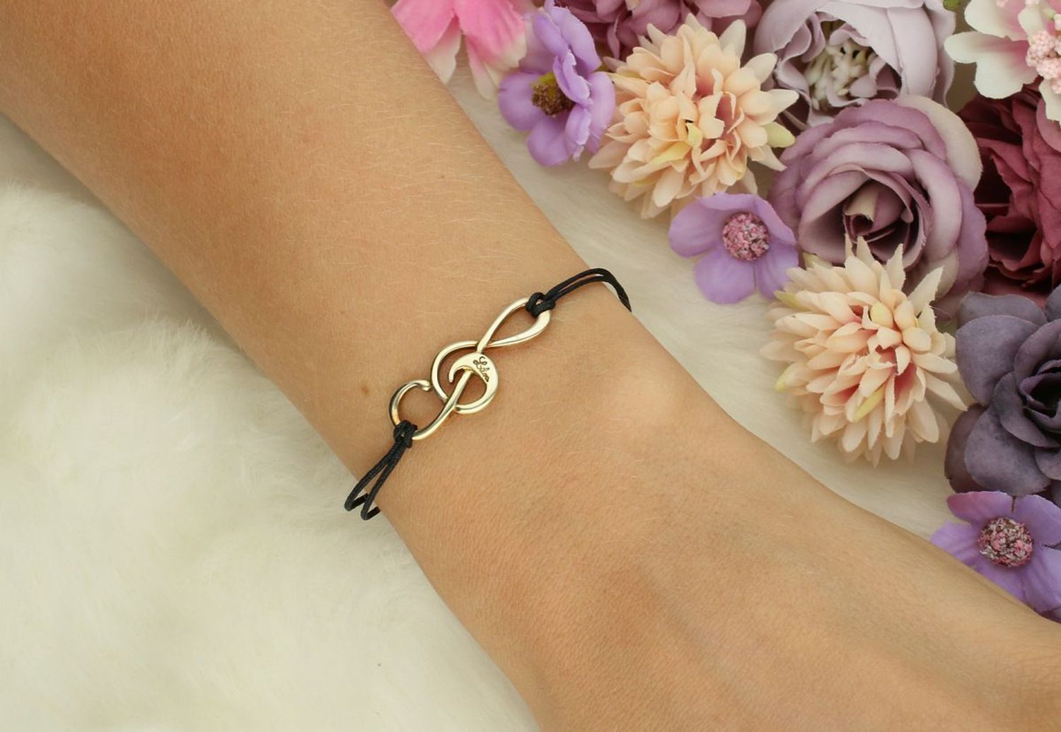 Muzyczna bransoletka damska na czarnym rzemyku z kluczem wiolinowym. Pozłacane srebro 925, zawieszka 3,0 x 1,1 cm, regulowane zapięcie. Idealna dla każdej miłośniczki muzyki.1.jpg