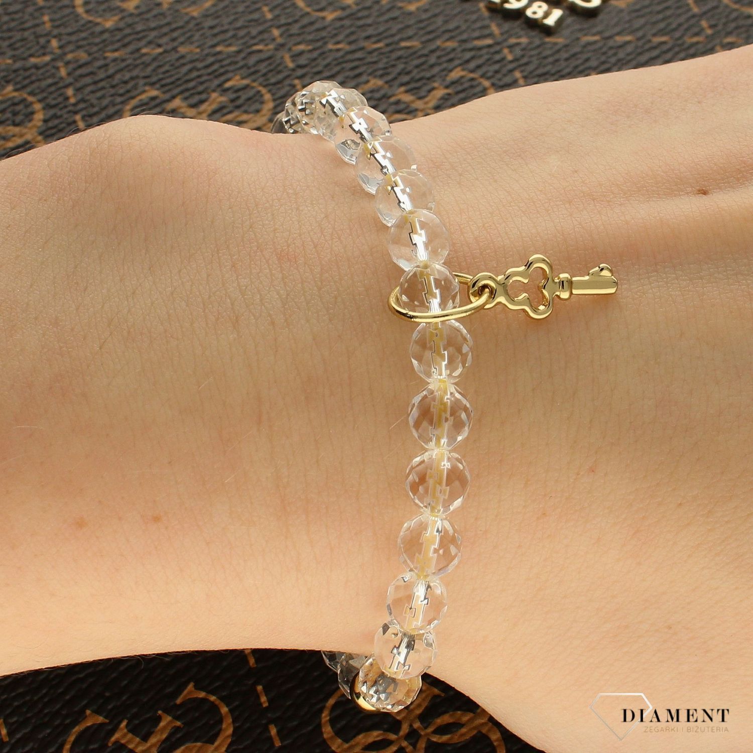 Bransoletka damska koraliki z zawieszką kluczem DIA-BRA-KORALIKI-KLUCZ. Wyjątkowa damska bransoletka z przezroczystych koralików i zawieszki pozłacanej 24K złotem w kształcie klucza.  (2).jpg