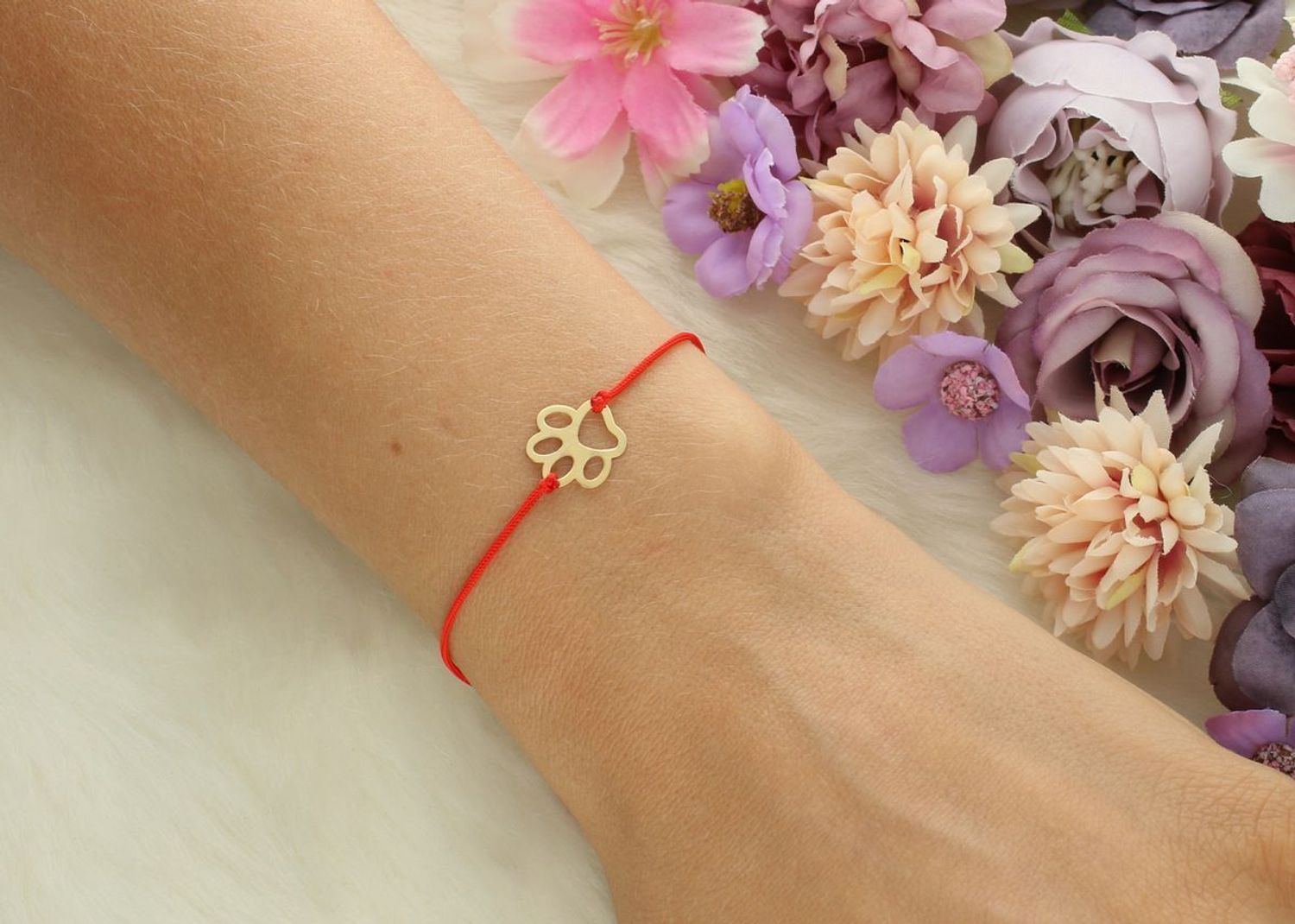 Złota bransoletka damska próby 585 z czerwoną nitką i zawieszką w kształcie psiej łapki (1,1 cm). Regulowane zapięcie, waga 0,44 g. Model DIA-BRA-LU104G14KRED – subtelna i symboliczna.1.jpg