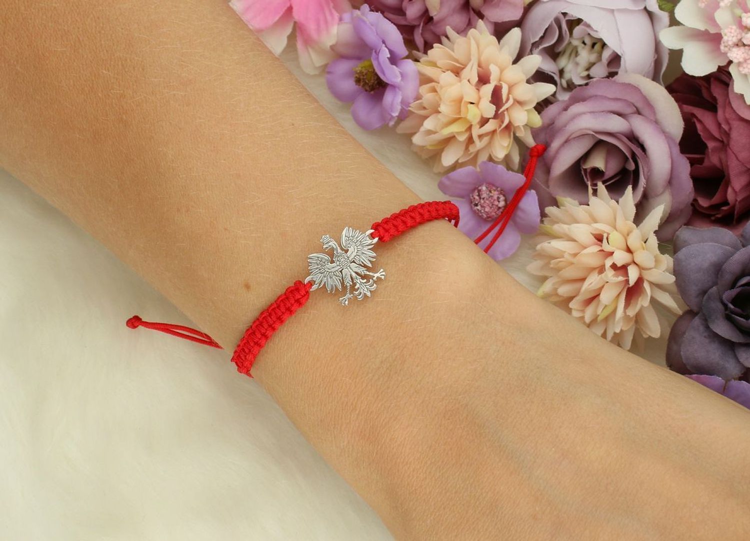Bransoletka damska ze srebra próby 925 z czerwoną nitką i zawieszką orzełkiem (1,3 x 1,5 cm). Regulowane zapięcie. Model DIA-BRA-ORZEŁ-925-CZER – elegancka, patriotyczna biżuteria.1.jpg
