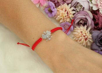 Bransoletka damska ze srebra próby 925 z czerwoną nitką i zawieszką orzełkiem (1,3 x 1,5 cm). Regulowane zapięcie. Model DIA-BRA-ORZEŁ-925-CZER – elegancka, patriotyczna biżuteria.2.jpg