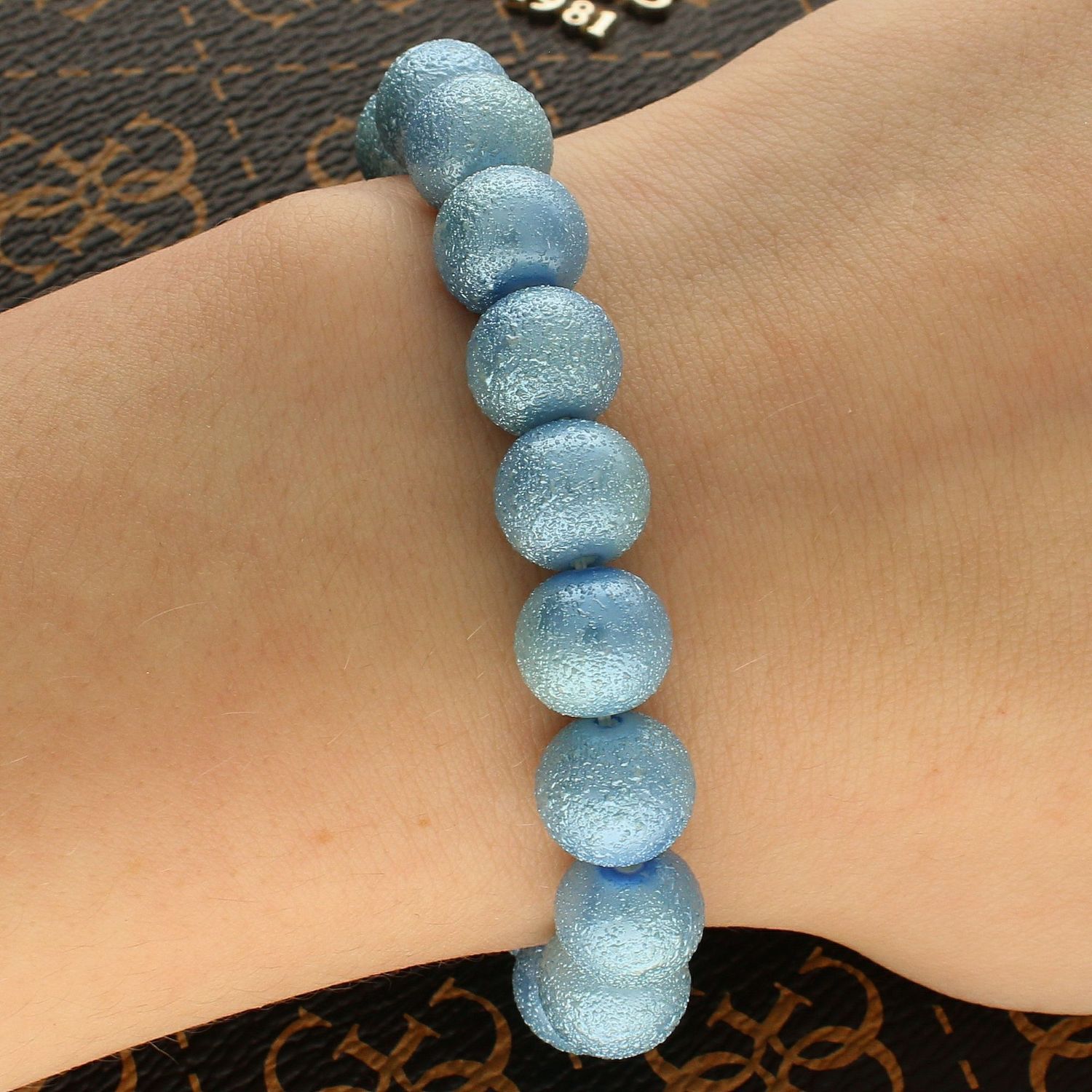 Bransoletka damska koraliki błękitne DIA-BRA-PUDROWE-KORALIKI1. Subtelna bransoletka na gumce, wykonana z koralików w błękitnym kolorze z charakterystyczną fakturą. Bransoletka damska z koralików (1).jpg