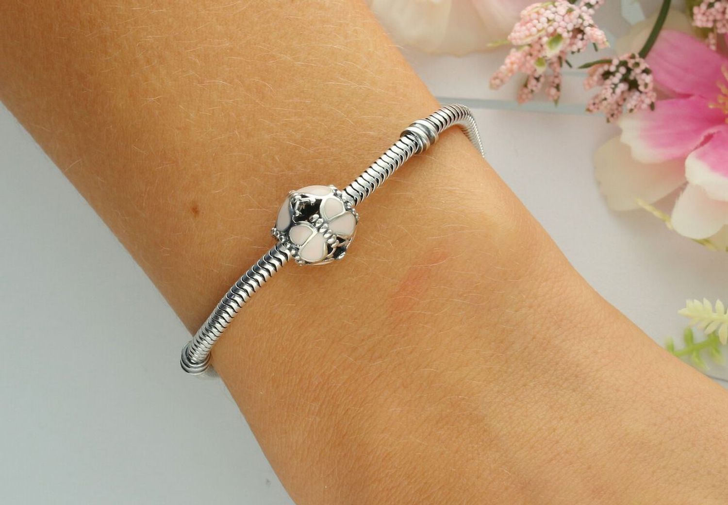 Okrągły charms srebrny próby 925 zdobiony motylkami i różową emalią. Lekki i kobiecy dodatek do bransoletki modułowej. Waga 2,20 g, wielkość 1,0 cm.10.jpg