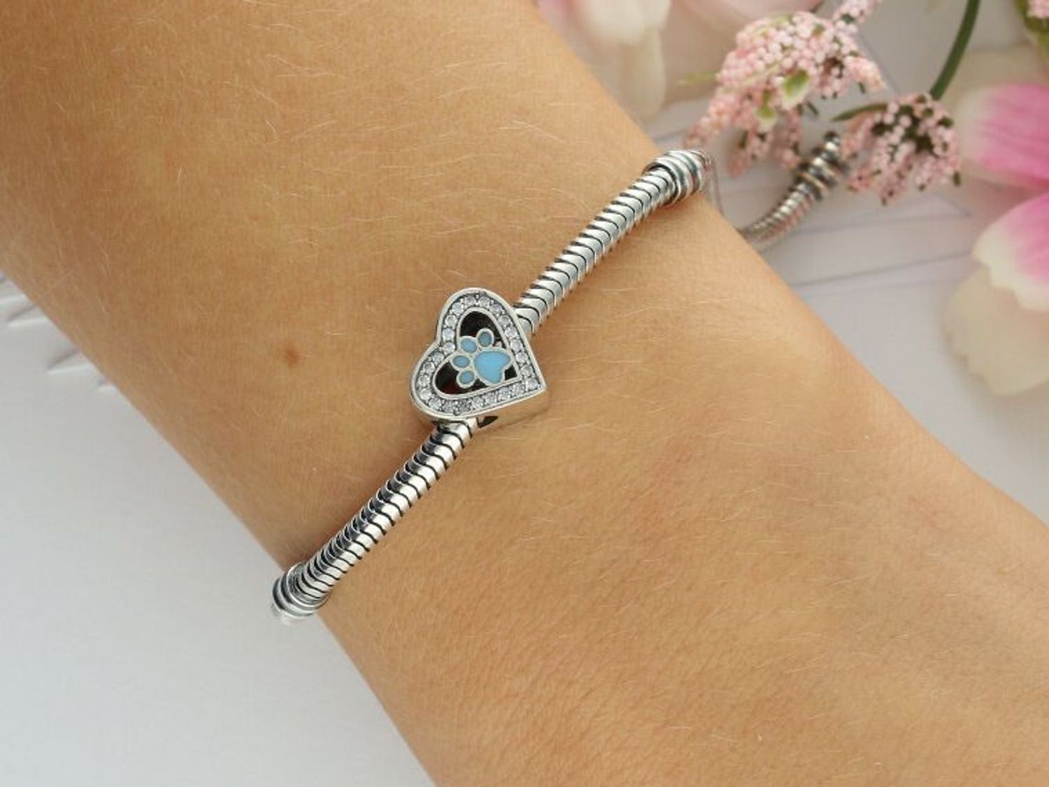 Odkryj uroczy charms srebrny próby 925 w kształcie serduszka z łapką pieska i niebieską emalią. Zdobiony cyrkoniami, idealny dla miłośniczek zwierząt. Waga 2,60 g, wielkość 1,0 cm.1.jpg