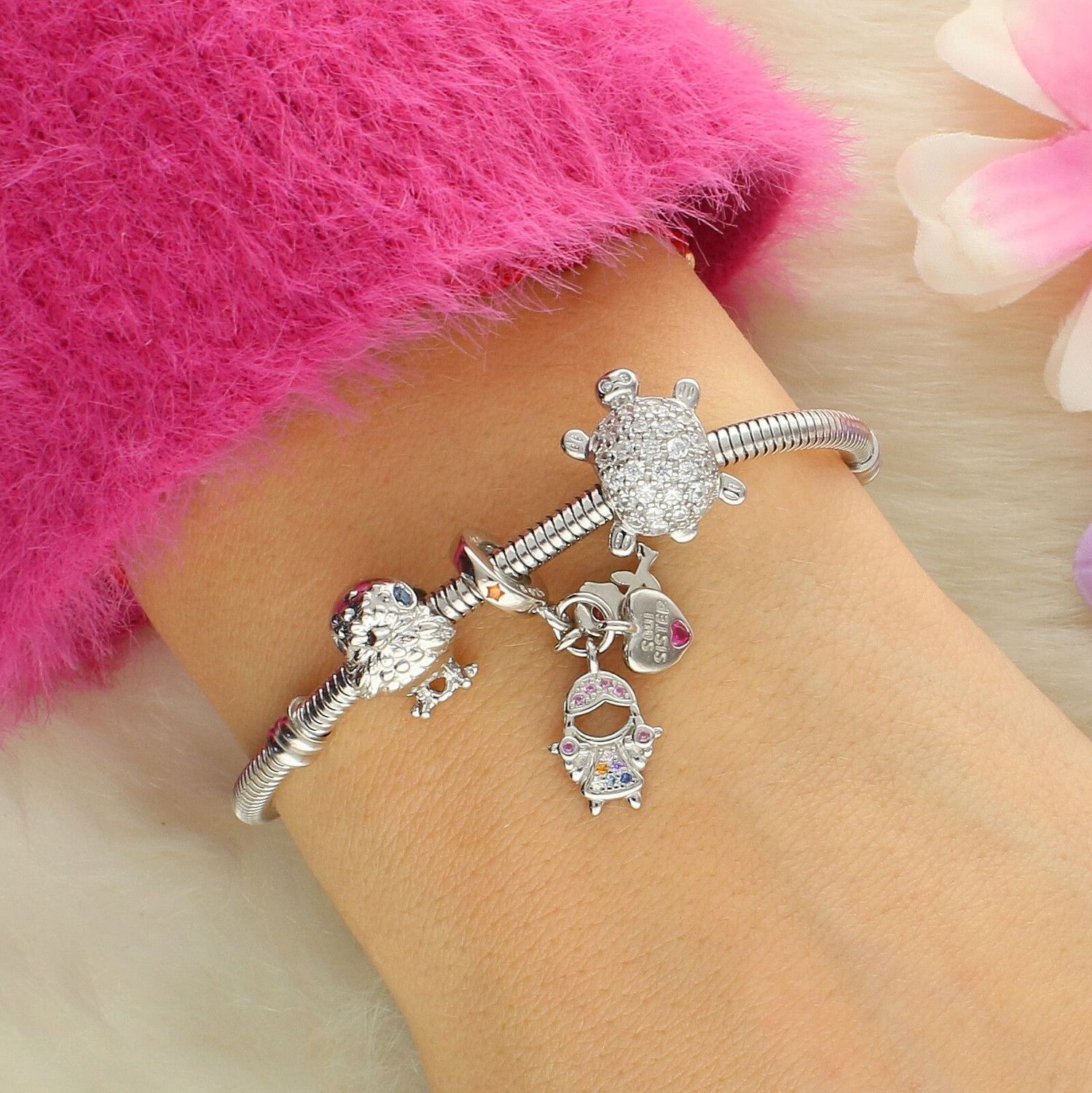 Charms srebrny próby 925 przedstawiający dziewczynkę z kwiatkiem i serduszkiem z napisem „Sister”, zdobiony kolorowymi cyrkoniami. Idealny do bransoletek modułowych, doskonały prezent dla siostry.1.jpg