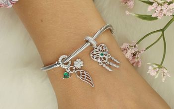 Charms srebrny 925 z trzema zawieszkami – serce, skrzydło i koniczynka. Rodowane srebro, zielona cyrkonia. Symbol szczęścia, miłości i wolności. Model DIA-CHA-IM00160624CH-925.4.jpg