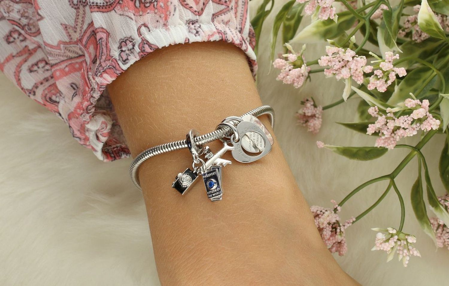 Charms srebrny 925 z motywem podróżniczym – samolot, aparat i paszport. Ozdobiony cyrkoniami w kolorze białym i niebieskim. Idealny prezent dla miłośników podróży. Model DIA-CHA-IM0530525CH-925.2.webp