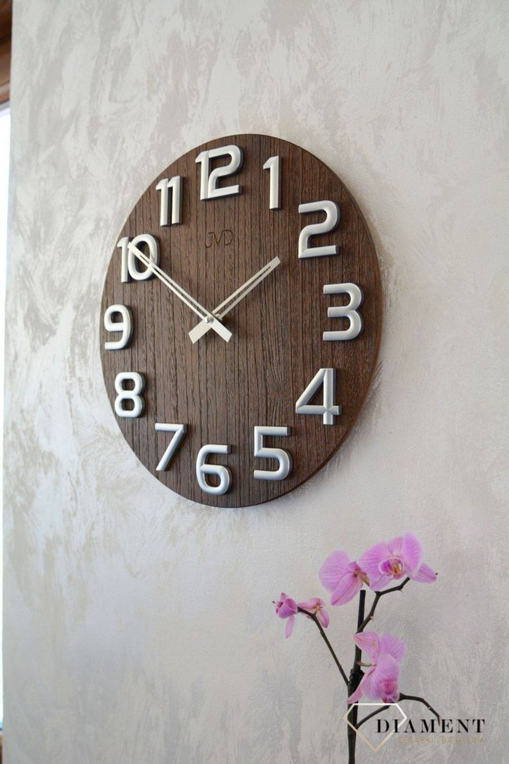 Nowoczesny zegar ścienny HT97.3 wyposażony jest w kwarcowy mechanizm, zasilany za pomocą baterii. Posiada bardzo wysoką dokładność mierzenia czasu +- 10 sekund w przeciągu 30 dni..webp