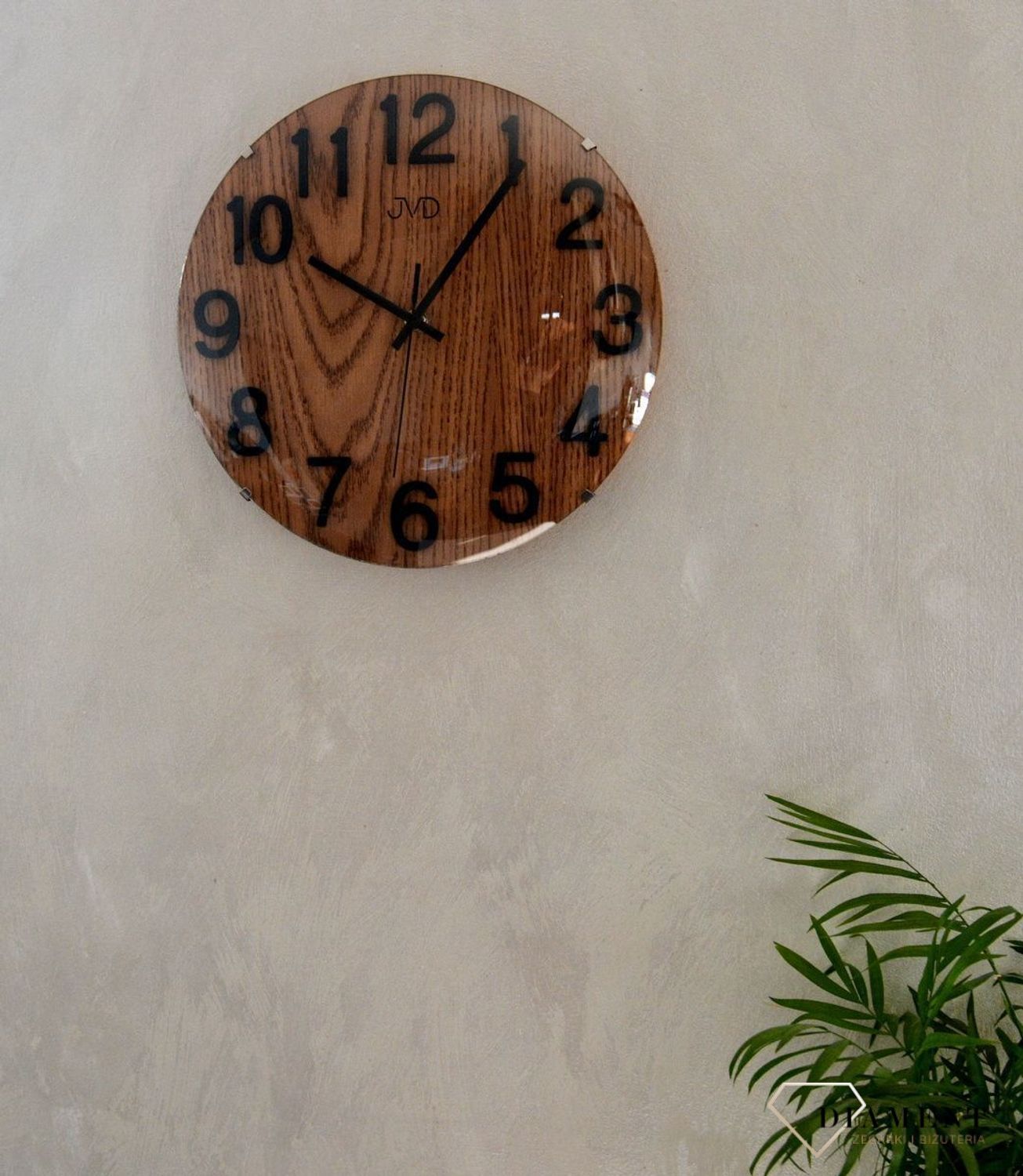 Zegar na ścianę drewniany JVD 30 cm HT98.7. Ścienny zegar JVD HT98.7 wyposażony jest w kwarcowy mechanizm, zasilany za pomocą baterii. Posiada bardzo wysoką dokładność mierzenia czasu +- 10 sekund w przeciągu 30 dni..jpg