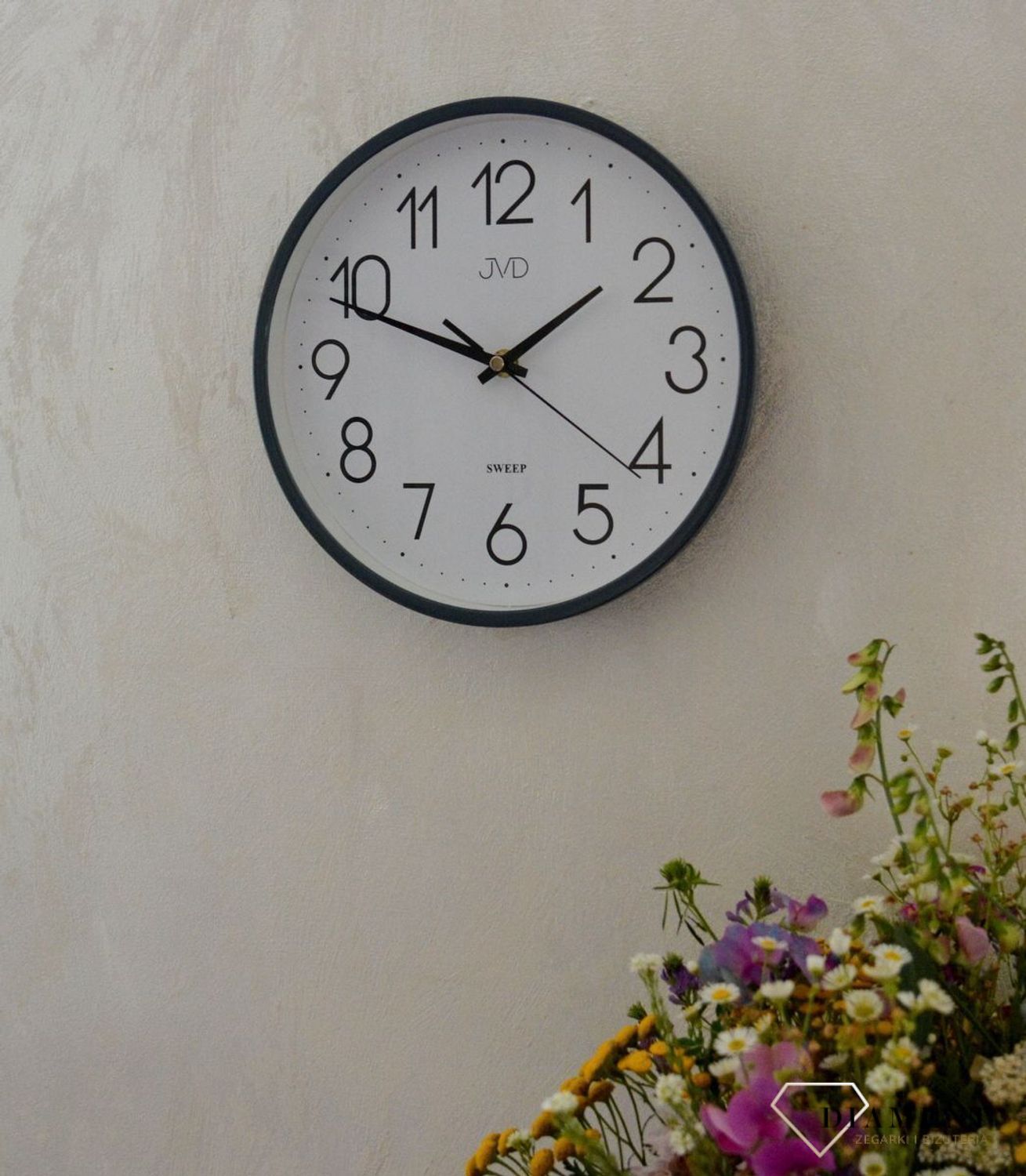 Ścienny zegar JVD HX2487.3 wyposażony jest w kwarcowy mechanizm, zasilany za pomocą baterii. Posiada bardzo wysoką dokładność mierzenia czasu +- 10 sekund w przeciągu 30 dni..jpg