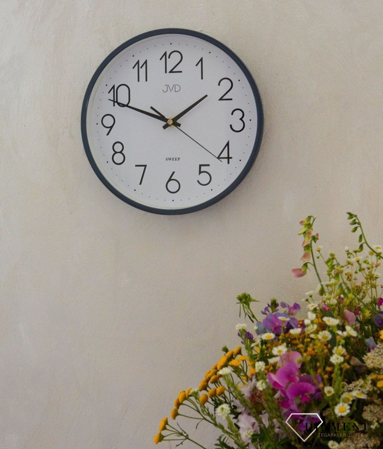 Ścienny zegar JVD HX2487.3 wyposażony jest w kwarcowy mechanizm, zasilany za pomocą baterii. Posiada bardzo wysoką dokładność mierzenia czasu +- 10 sekund w przeciągu 30 dni..jpg