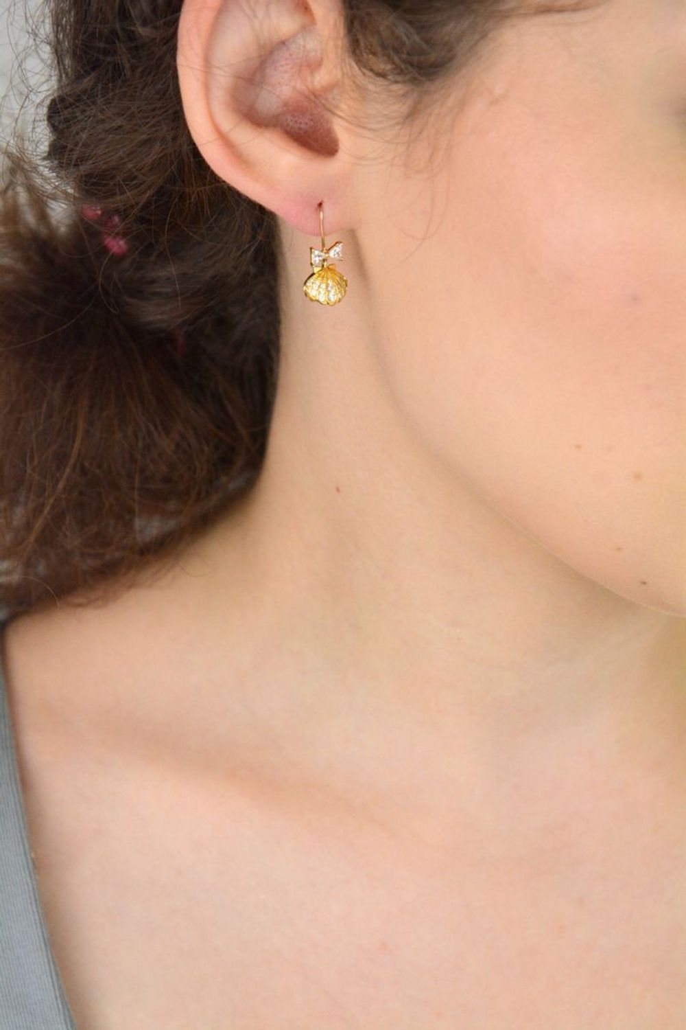 Eleganckie kolczyki damskie srebrne pozłacane próby 925 – model DIA-KLC-13655-925. Wiszące muszelki z białą perłą i kokardką z cyrkonii. Zapięcie bigiel otwarty. Lekkie, subtelne – idealne na pr.jpg