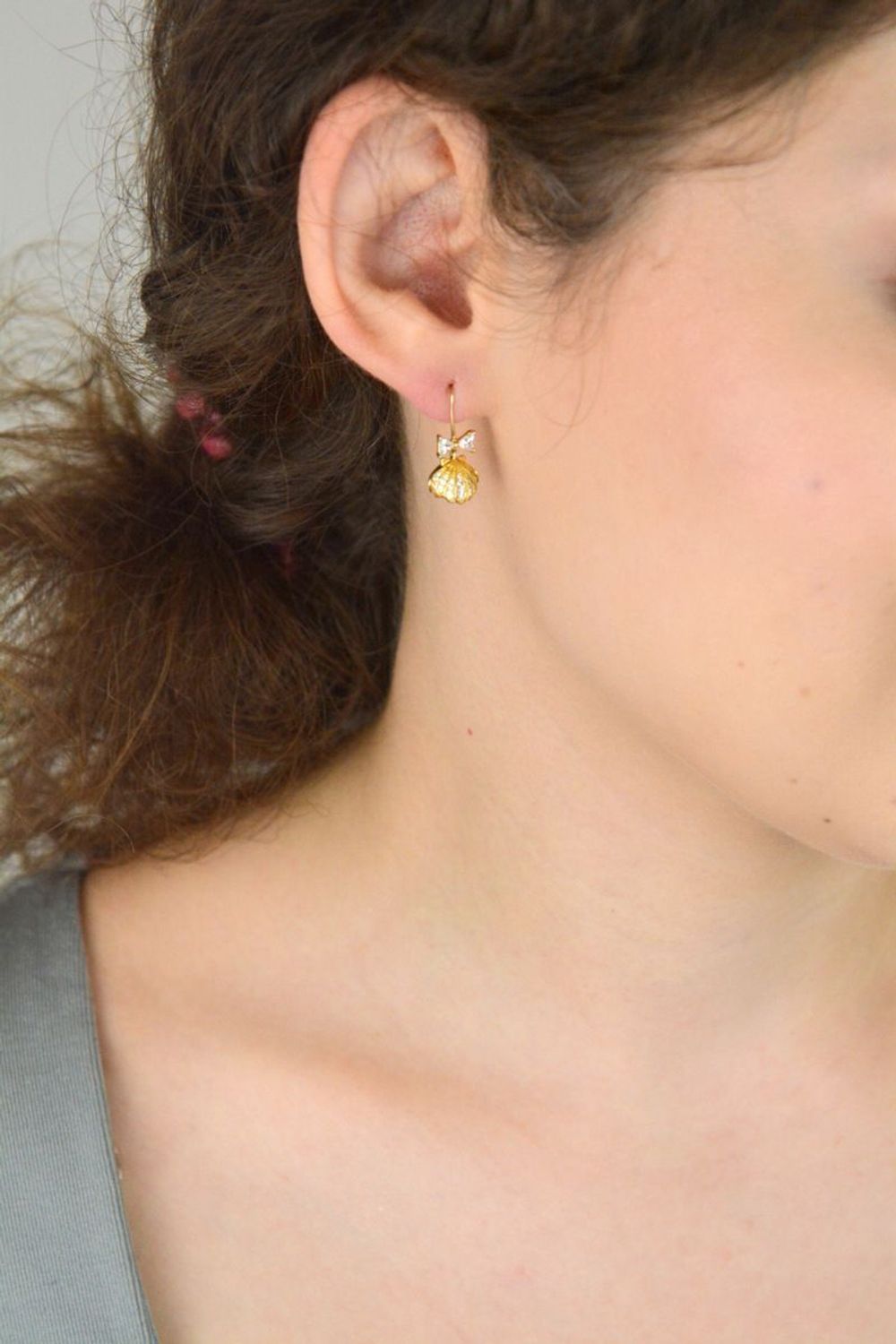 Eleganckie kolczyki damskie srebrne pozłacane próby 925 – model DIA-KLC-13655-925. Wiszące muszelki z białą perłą i kokardką z cyrkonii. Zapięcie bigiel otwarty. Lekkie, subtelne – idealne na pr.jpg