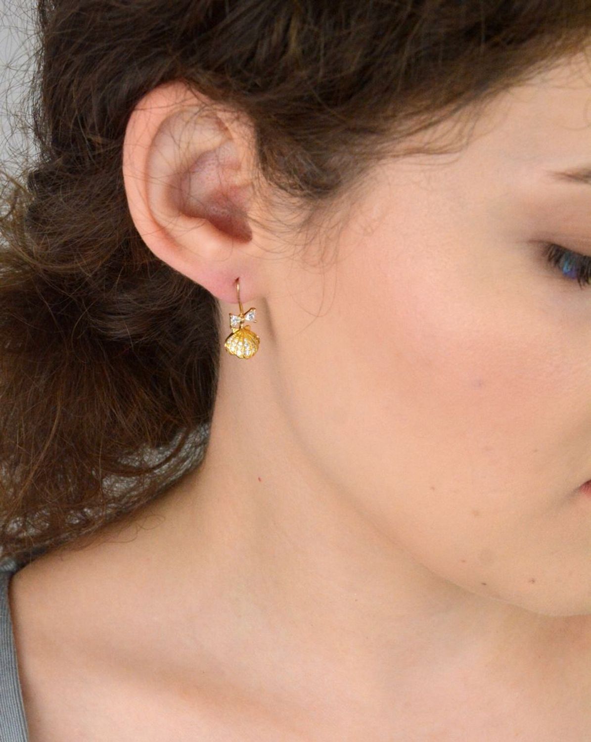 Eleganckie kolczyki damskie srebrne pozłacane próby 925 – model DIA-KLC-13655-925. Wiszące muszelki z białą perłą i kokardką z cyrkonii. Zapięcie bigiel otwarty. Lekkie, subtelne – idealne na pr.jpg