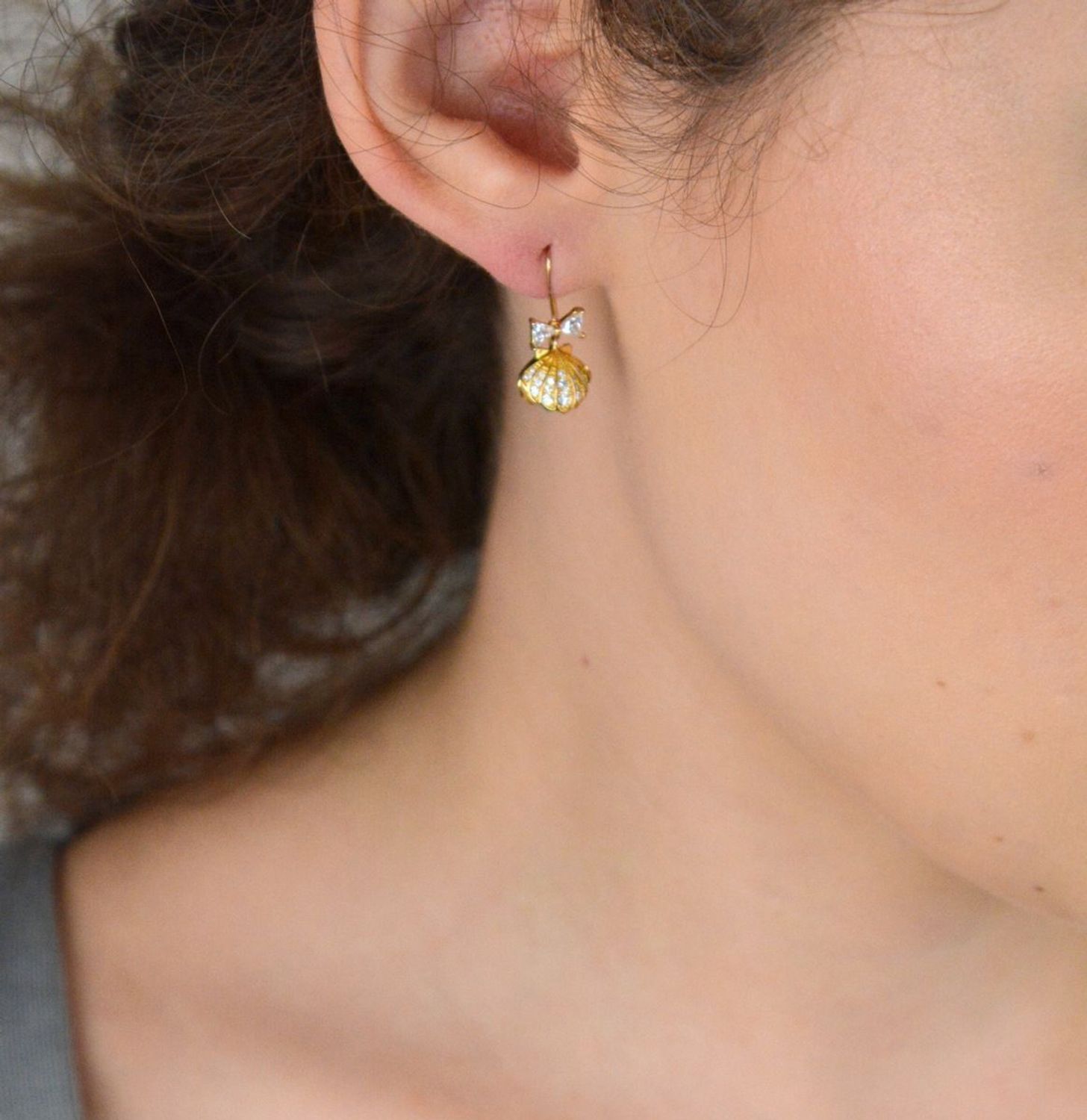 Eleganckie kolczyki damskie srebrne pozłacane próby 925 – model DIA-KLC-13655-925. Wiszące muszelki z białą perłą i kokardką z cyrkonii. Zapięcie bigiel otwarty. Lekkie, subtelne – idealne na pr.jpg