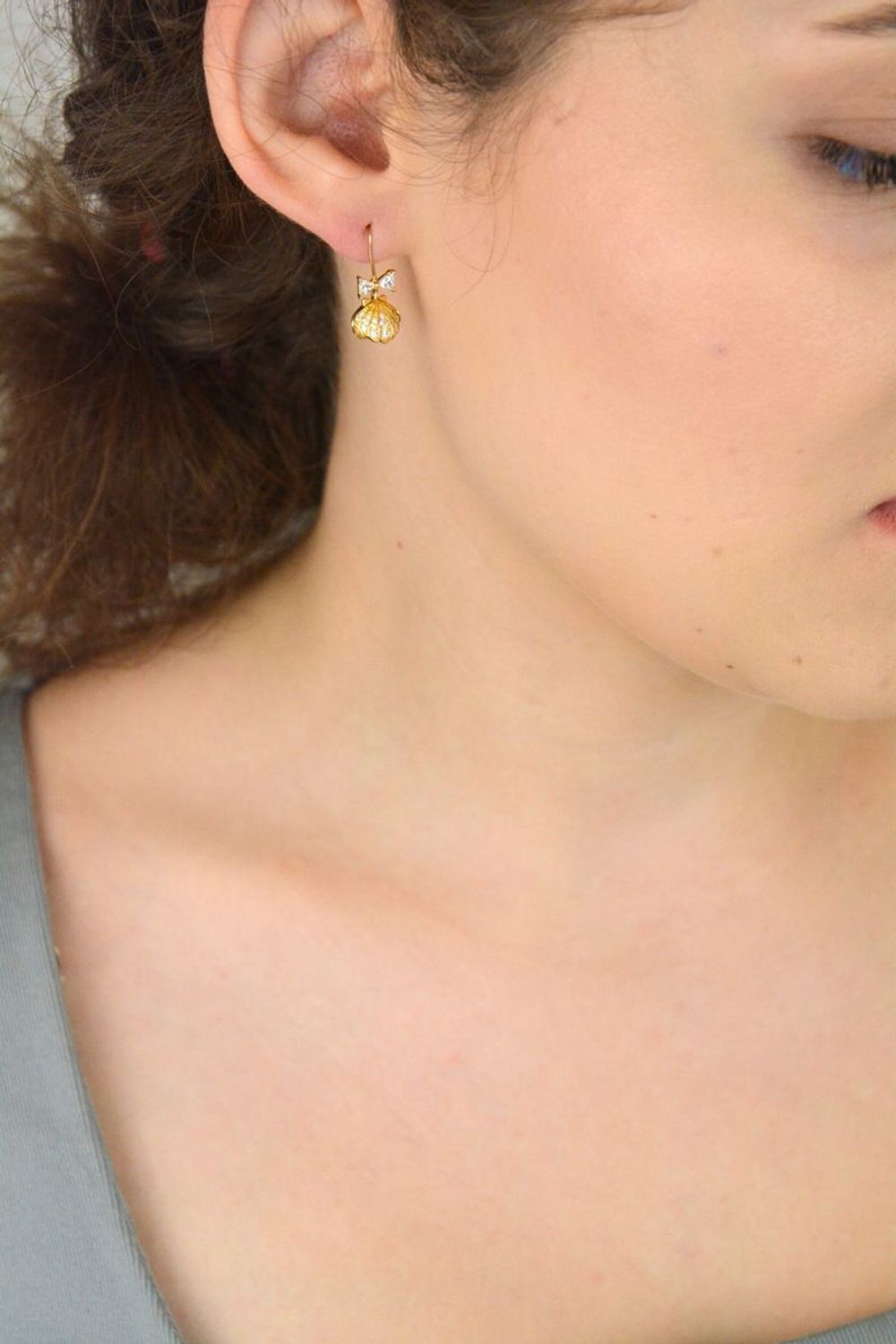 Eleganckie kolczyki damskie srebrne pozłacane próby 925 – model DIA-KLC-13655-925. Wiszące muszelki z białą perłą i kokardką z cyrkonii. Zapięcie bigiel otwarty. Lekkie, subtelne – idealne na pr.jpg