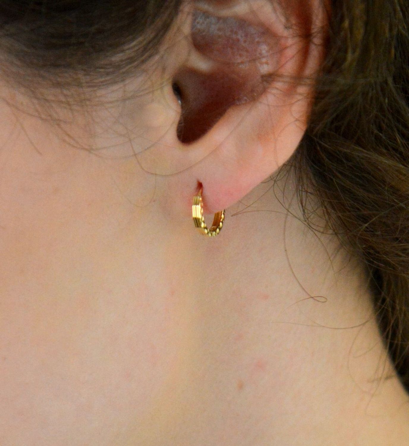 Kolczyki damskie złote DIA-KLC-13745-585 – małe kółeczka zdobione grawerem. Wymiary 1,0 cm x 2 mm, waga 0,86 g. Subtelna i elegancka biżuteria, idealna na prezent.1.jpg