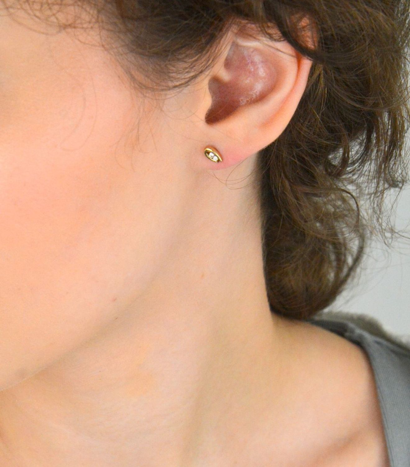 Subtelne złote kolczyki damskie DIA-KLC-1621-333 próby 333 z dwiema cyrkoniami. Lekkie (0,93g), w rozmiarze 6x3 mm, z wygodnym zapięciem na sztyft. Idealne na co dzień lub dla dziecka.1.jpg