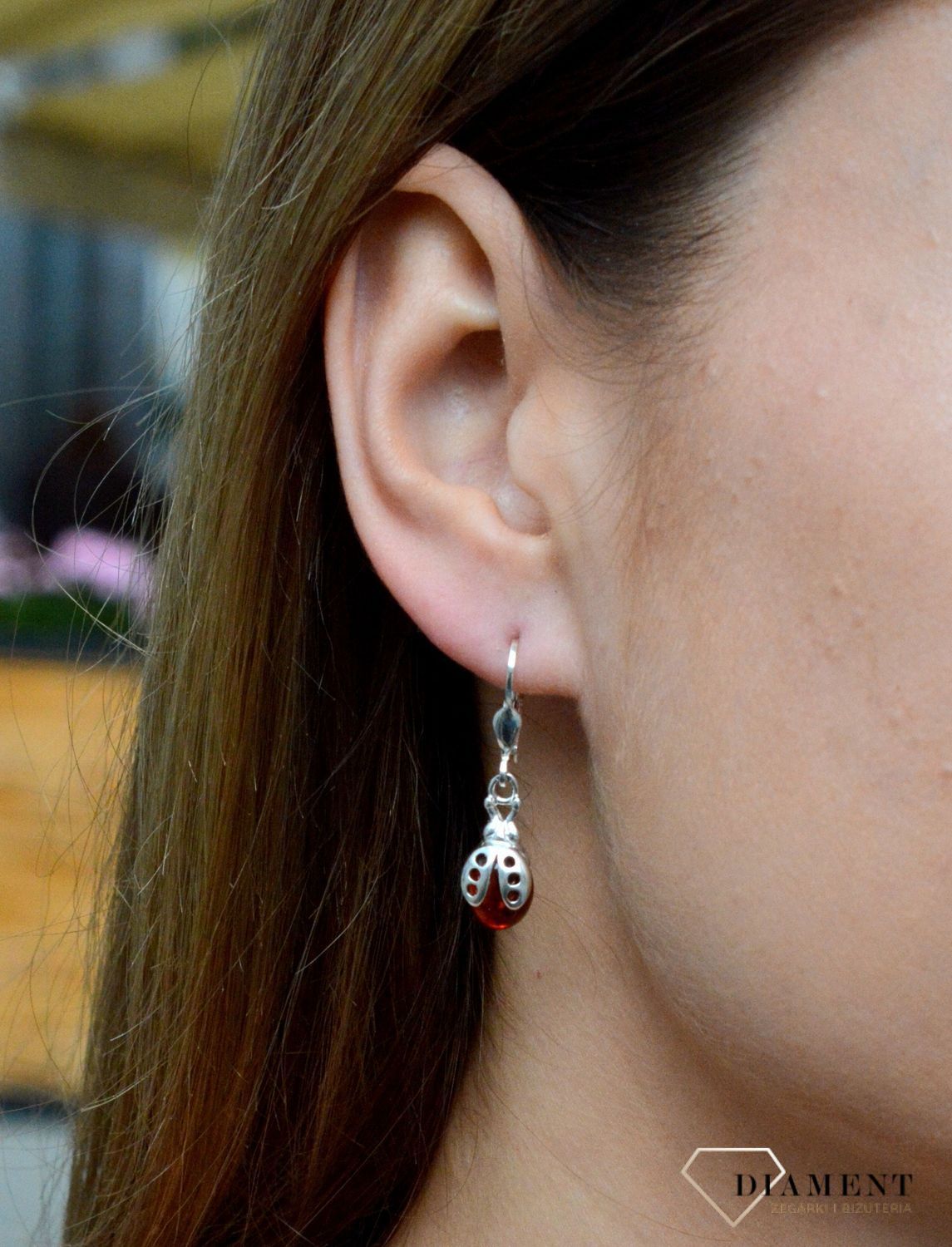 Kolczyki srebrne wiszące biedronki z bursztynem DIA-KLC-2467-925. Srebrne kolczyki z bursztynem to modelem bardzo ciekawy, ponieważ dzięki ciepłej kolorystyce pięknie podkreśla on urodę. Charakteryzują się stylem wiszącym i za.png