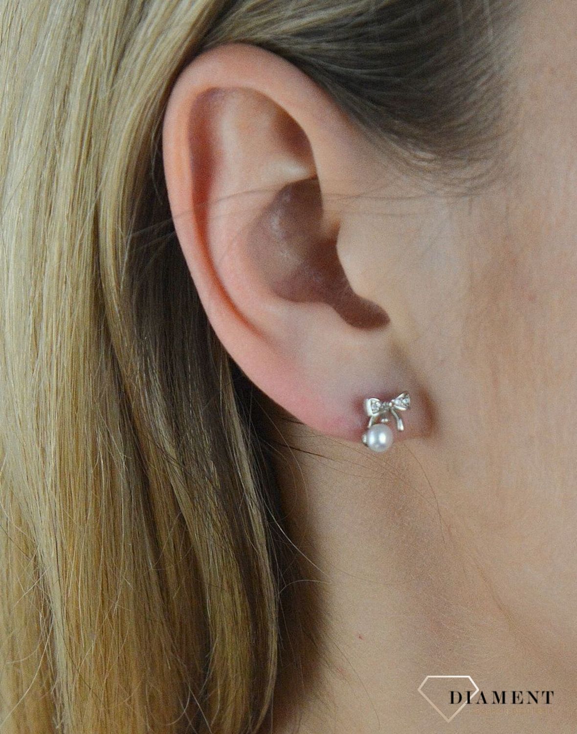 Srebrne kolczyki kokardki damskie z perełką DIA-KLC-5396-925. Kolczyki to idealna proporcje zamknięte w pięknej kompozycji. Kolczyki wykonane z najwyższej jakości srebra próby 925. Nowa interpretacja klasycznego wzoru ozdobi.png