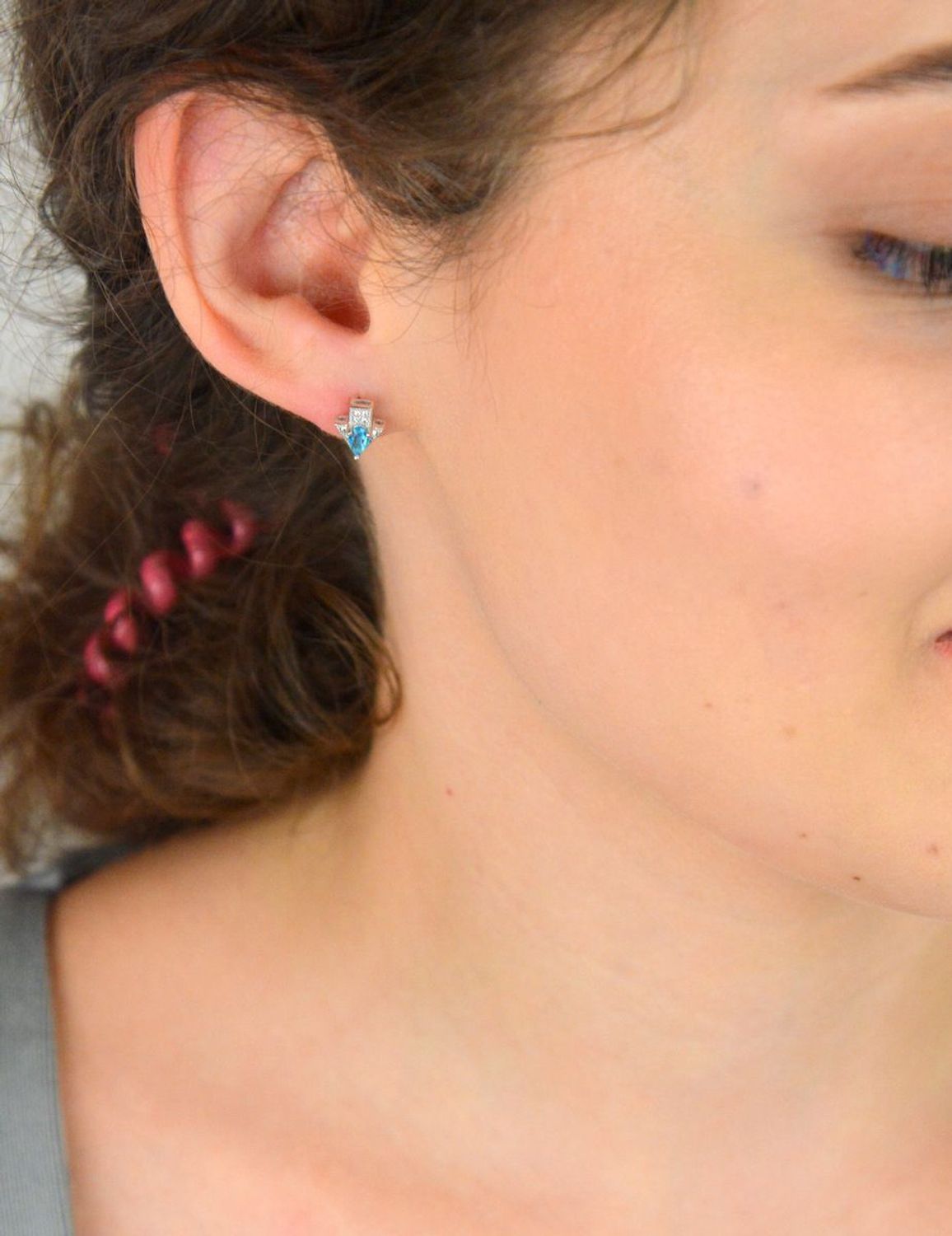 Srebrne kolczyki 925 w kształcie strzałek, ozdobione niebieską i białą cyrkonią. Wymiary 7 × 8 mm, waga 1,20 g, zapięcie na sztyft – subtelny geometryczny akcent.1.jpg