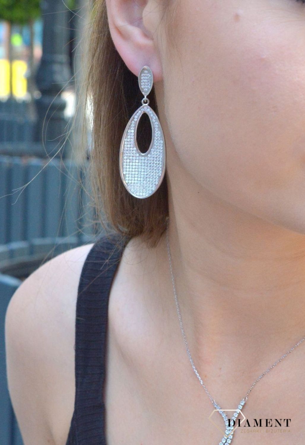 Kolczyki srebrne wiszące do ślubu w cyrkonie to nieskazitelne srebrne kolczyki w kształcie owalnym z białymi cyrkoniami. Zapięcie z tyłu na sztyfcie. Oryginalne i w nowoczesnym stylu podkreślające kobiecość.jpg