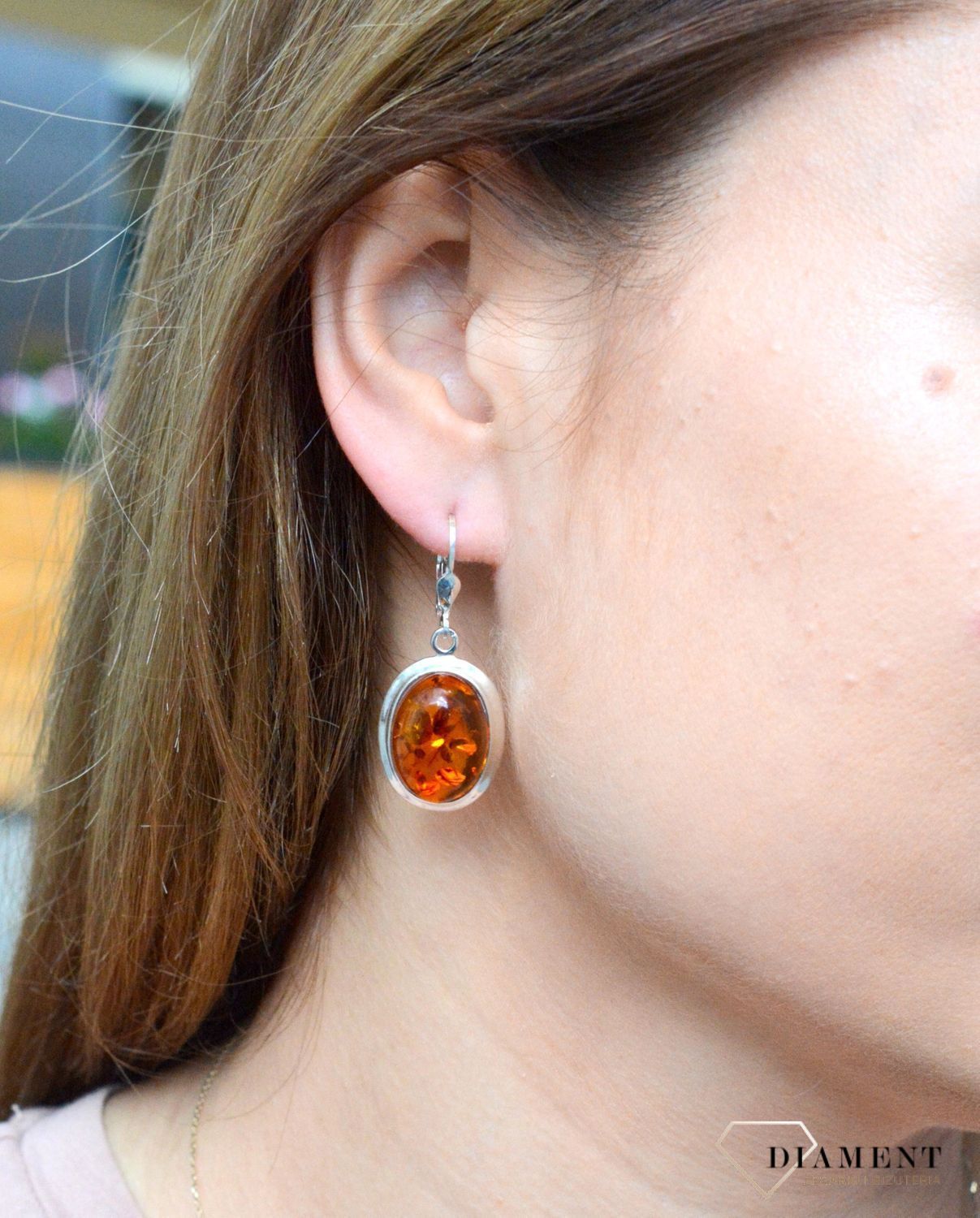 Kolczyki srebrne wiszące z owalnym bursztynem DIA-KLC-7079-925. Srebrne kolczyki z bursztynem to modelem bardzo ciekawy, ponieważ dzięki ciepłej kolorystyce pięknie podkreśla on urodę. Charakteryzują się stylem wiszącym i zaw.jpg