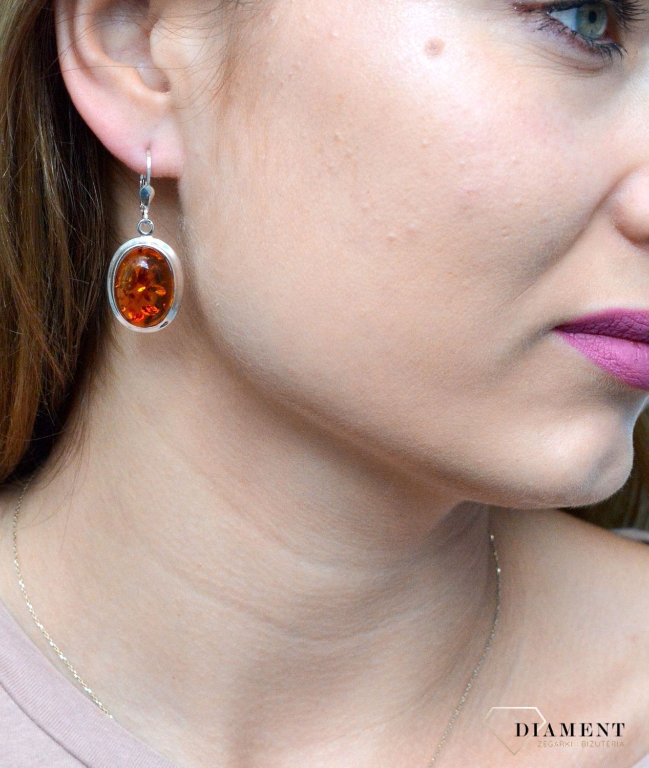 Kolczyki srebrne wiszące z owalnym bursztynem DIA-KLC-7079-925. Srebrne kolczyki z bursztynem to modelem bardzo ciekawy, ponieważ dzięki ciepłej kolorystyce pięknie podkreśla on urodę. Charakteryzują się stylem wiszącym i zaw.jpg