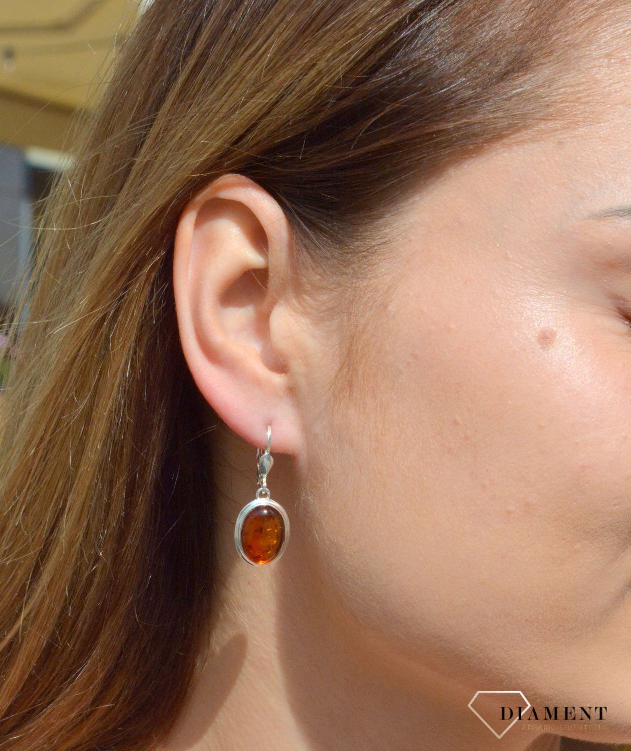 Kolczyki srebrne wiszące z owalnym bursztynem  DIA-KLC-7083-925. Srebrne kolczyki z bursztynem to modelem bardzo ciekawy, ponieważ dzięki ciepłej kolorystyce pięknie podkreśla on urodę.Charakteryzują się stylem wiszącym na tra.jpg