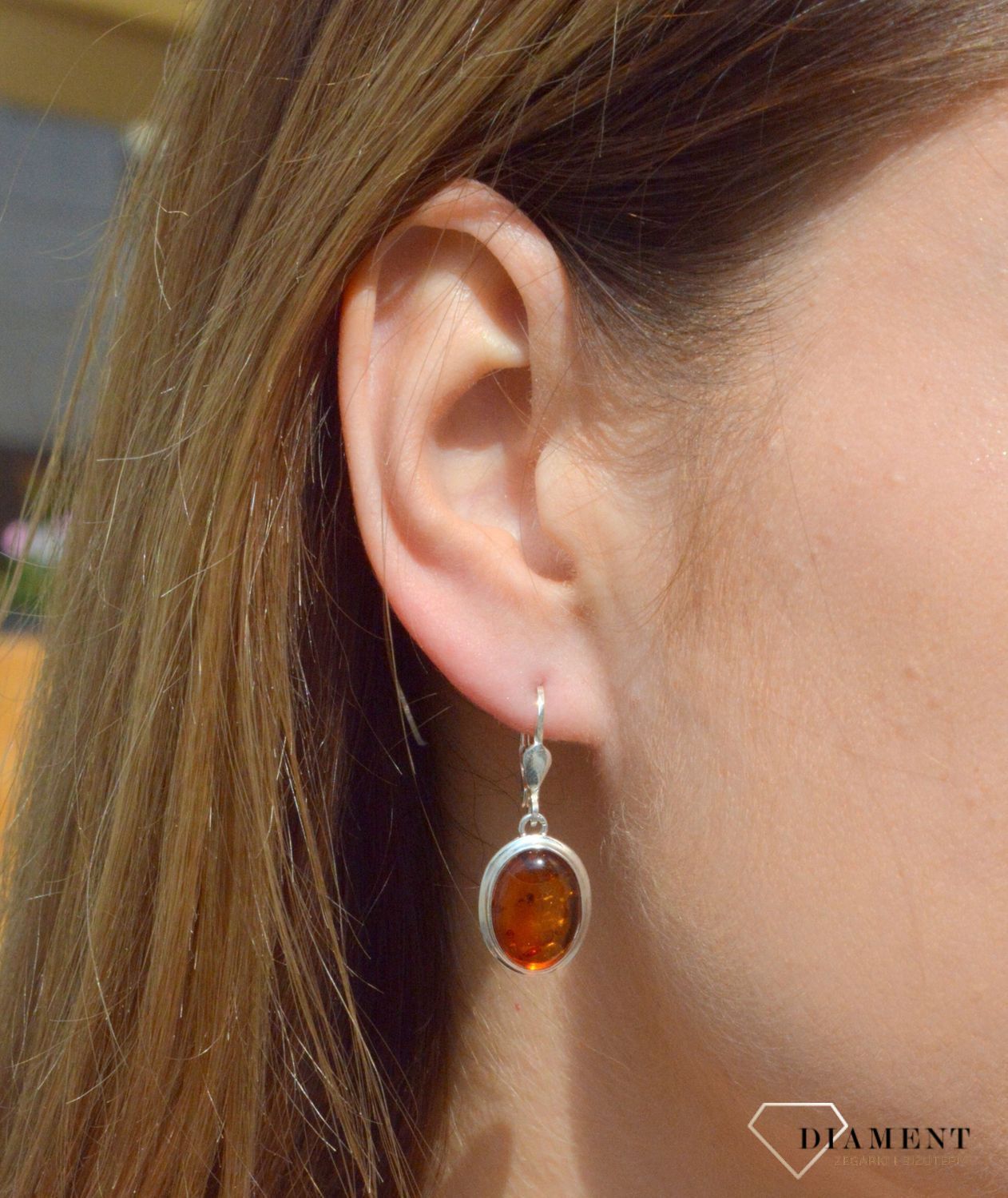 Kolczyki srebrne wiszące z owalnym bursztynem  DIA-KLC-7083-925. Srebrne kolczyki z bursztynem to modelem bardzo ciekawy, ponieważ dzięki ciepłej kolorystyce pięknie podkreśla on urodę.Charakteryzują się stylem wiszącym na tra.jpg