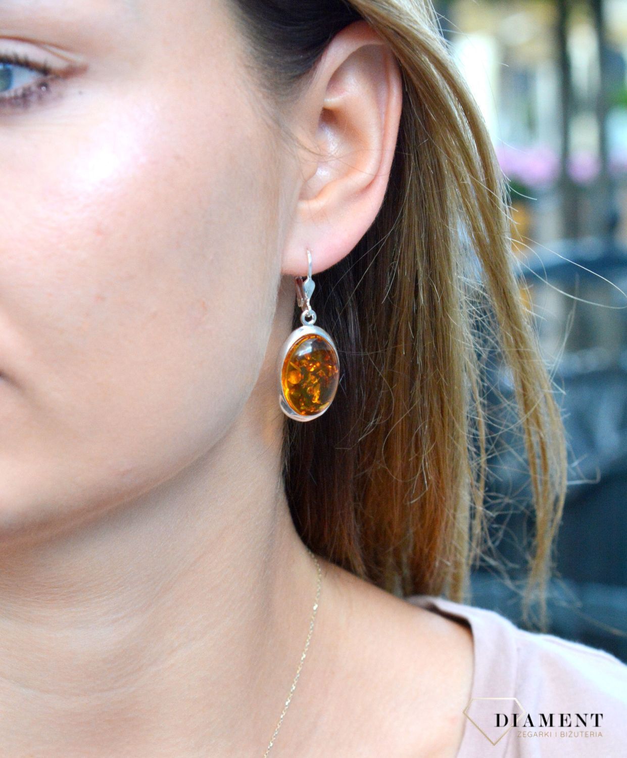 Kolczyki srebrne wiszące z dużym owalnym bursztynem DIA-KLC-7084-925. Srebrne kolczyki z bursztynem to modelem bardzo ciekawy, ponieważ dzięki ciepłej kolorystyce pięknie podkreśla on urodę.Charakteryzują się stylem wiszącym i.jpg