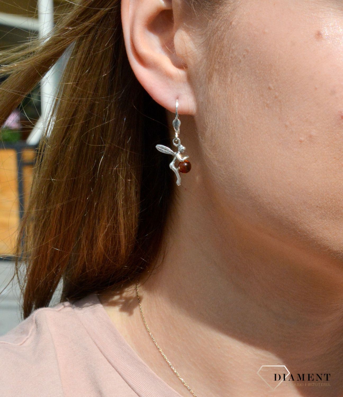 Kolczyki srebrne wiszące o kształcie aniołka z okrągłym bursztynem DIA-KLC-7086-925.  Srebrne kolczyki z bursztynem to modelem bardzo ciekawy, ponieważ dzięki ciepłej kolorystyce pięknie podkreśla on urodę. Charakteryzują się.jpg