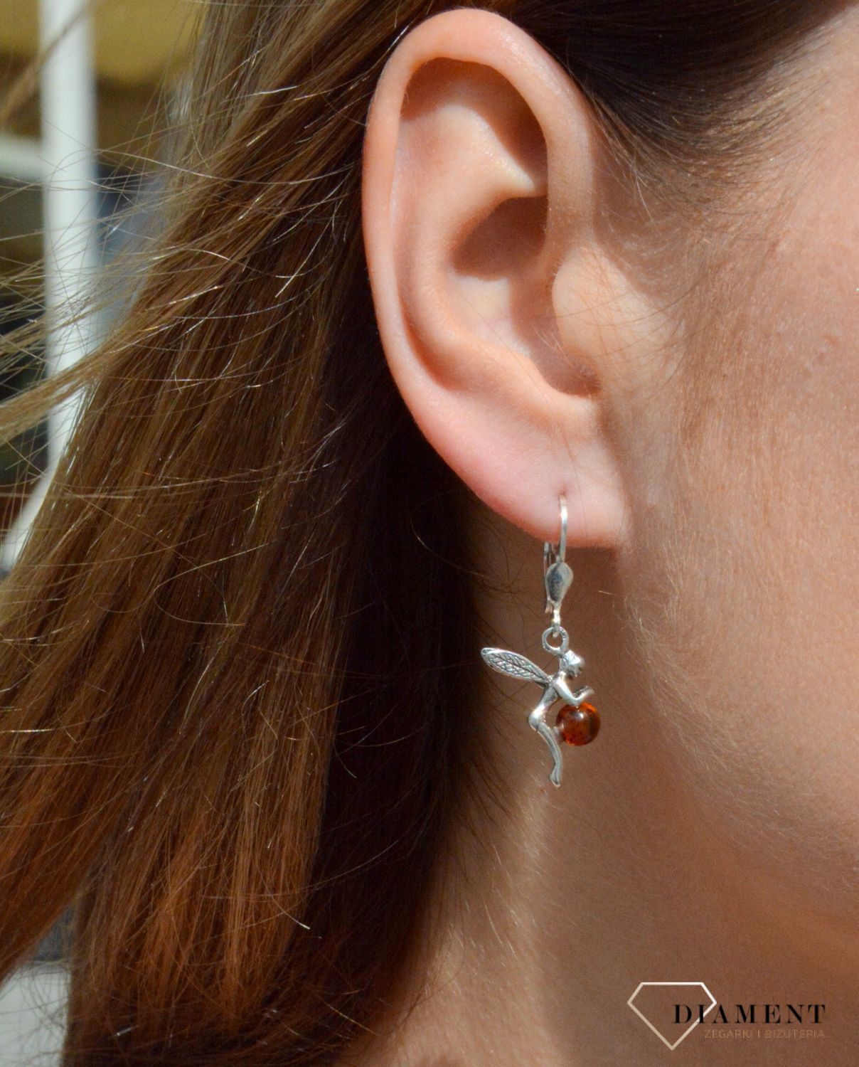 Kolczyki srebrne wiszące o kształcie aniołka z okrągłym bursztynem DIA-KLC-7086-925.  Srebrne kolczyki z bursztynem to modelem bardzo ciekawy, ponieważ dzięki ciepłej kolorystyce pięknie podkreśla on urodę. Charakteryzują się.jpg