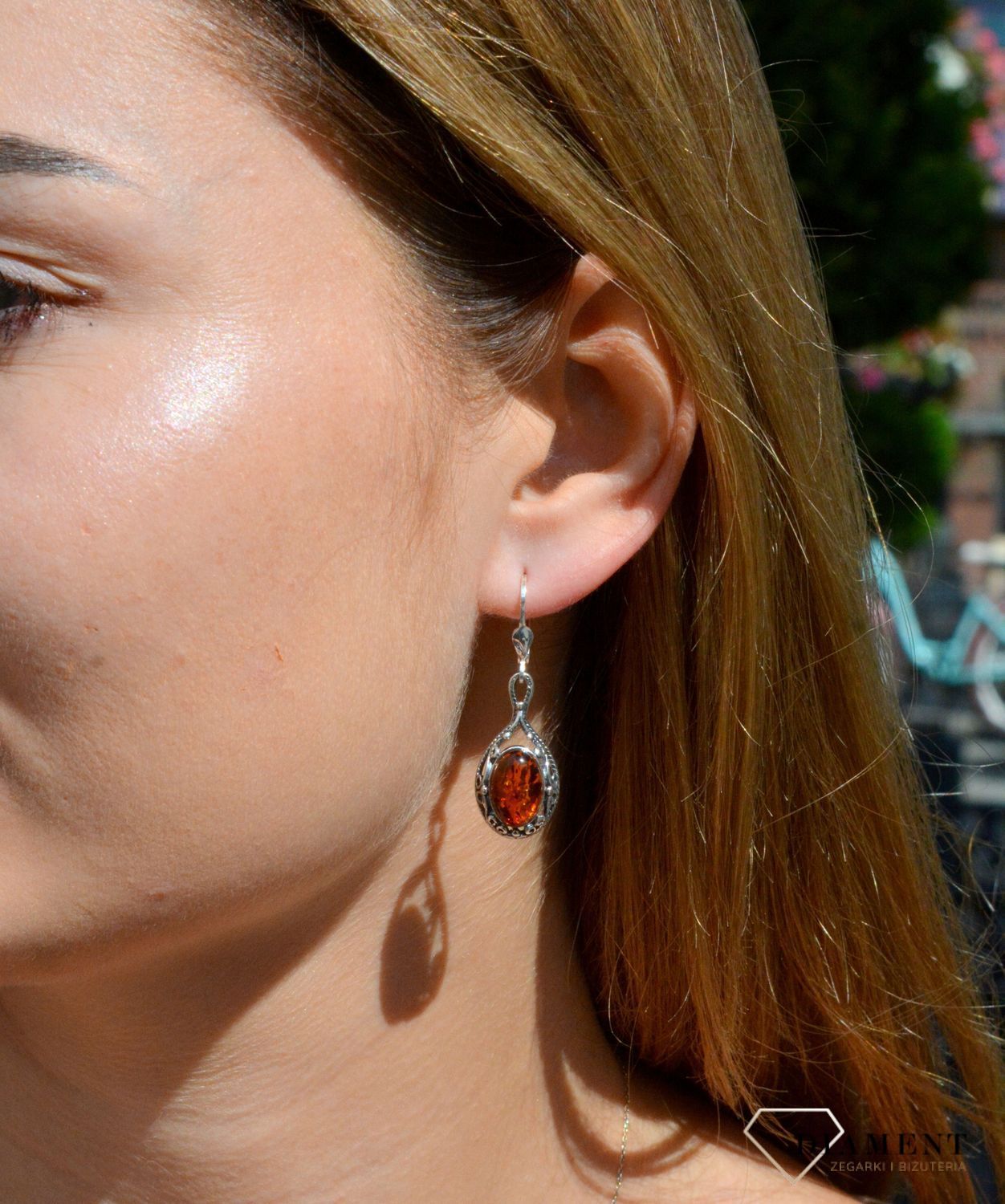 Kolczyki srebrne wiszące z owalnym bursztynem DIA-KLC-7101-925.  Srebrne kolczyki z bursztynem to modelem bardzo ciekawy, ponieważ dzięki ciepłej kolorystyce pięknie podkreśla on urodę. Charakteryzują się stylem wiszącym i są.jpg